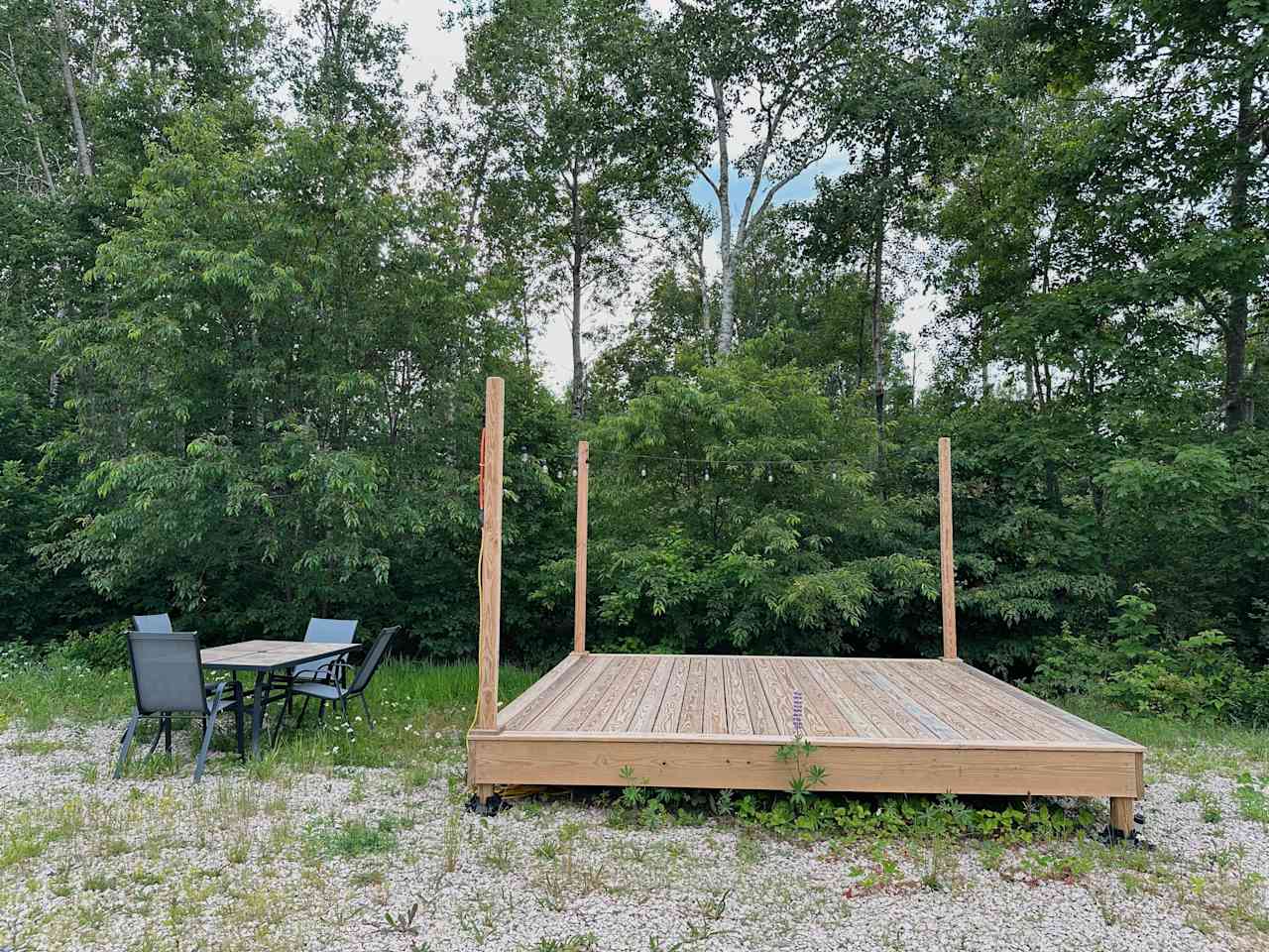 Tent platform with string lights and personal patio table set