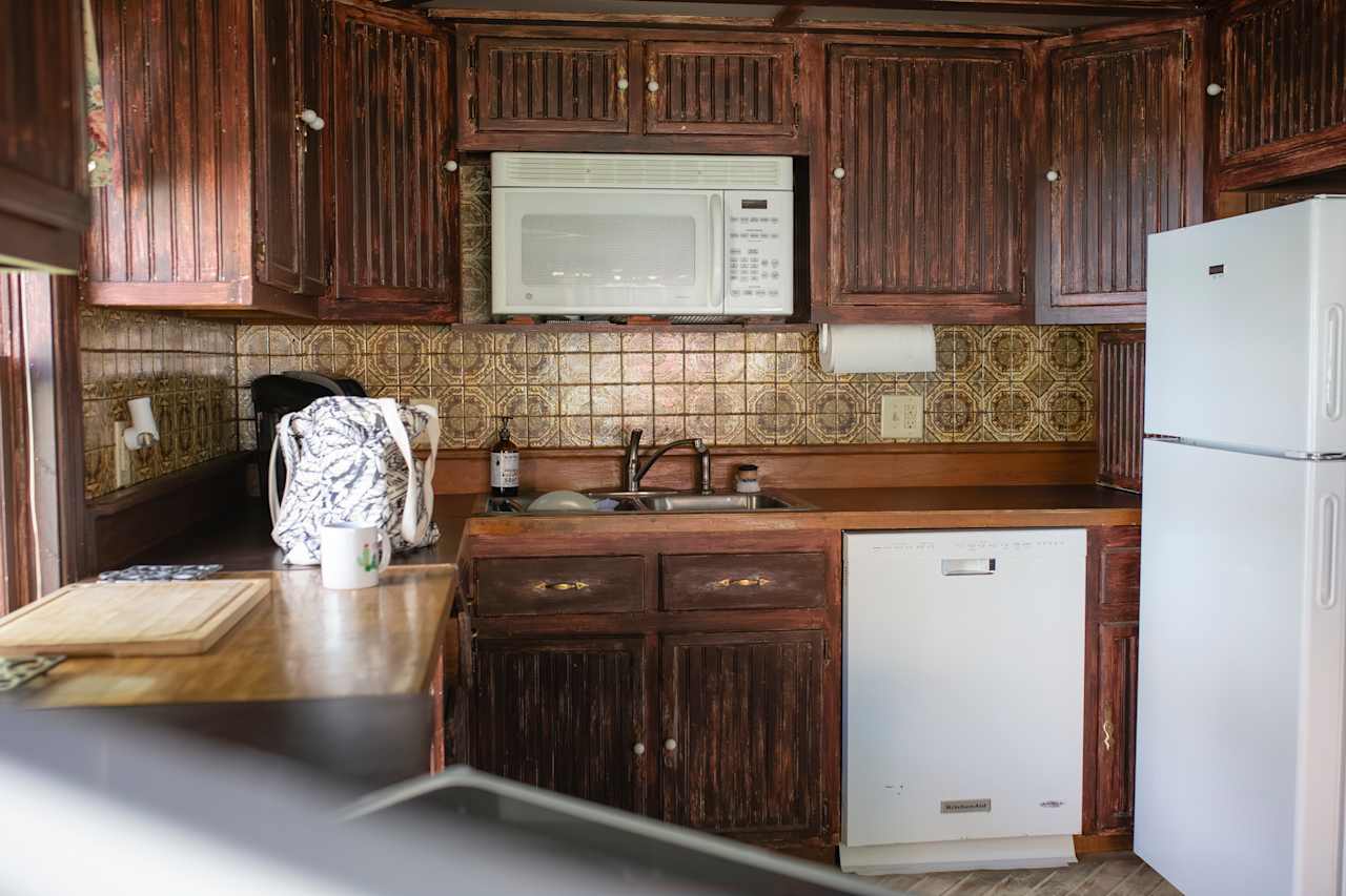 Large kitchen with oven/dishwasher/fridge and lots of utensils