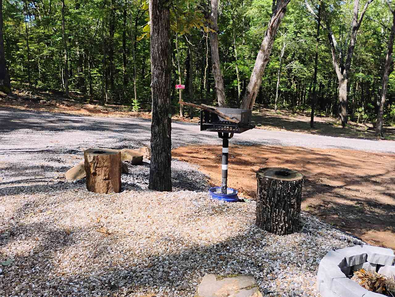 Park style BBQ grill with a stone fire pit.