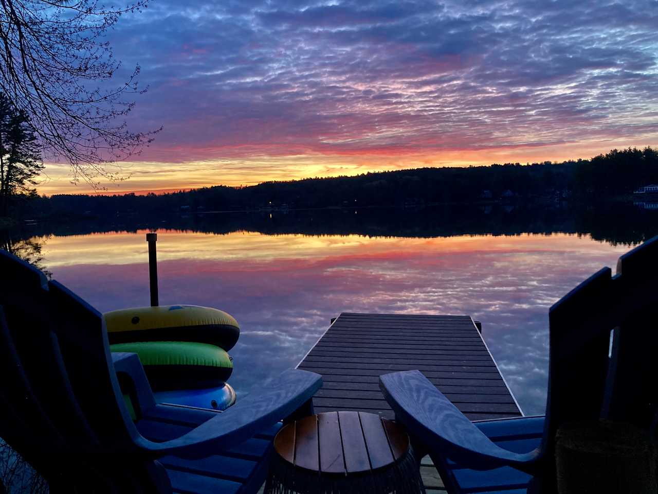 A calm lake mirrors a vibrant sunrise. 