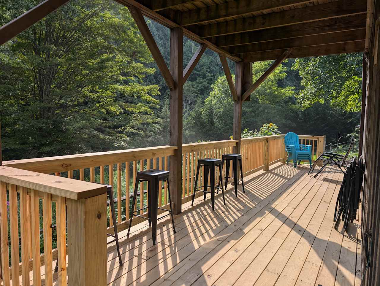 Partially covered deck overlooking flower gardens with lots of birds, butterflies, and bees flying around