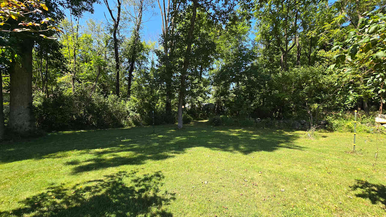 Site 4 for tents only.  40'x40' Set back with the most privacy. You can see the main house in the photo. There is a fire pit and table and chairs. 