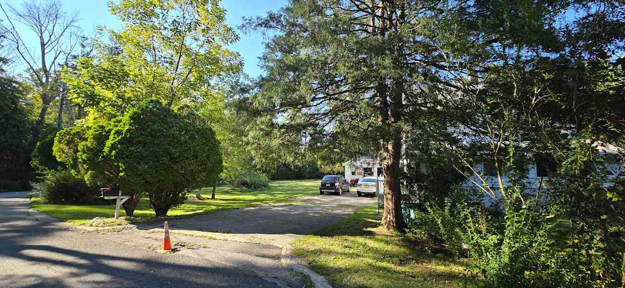 Driveway to the house. Site 2 is past the little black car in the photo. RVs will enter on the grass to the left of the big tree stump as shown in another photo.