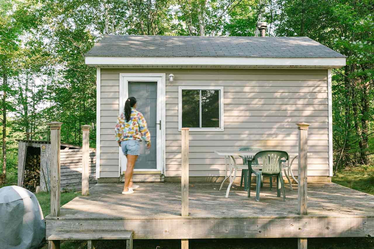 The cabin and its outdoor table for enjoying your meals under the shade. 