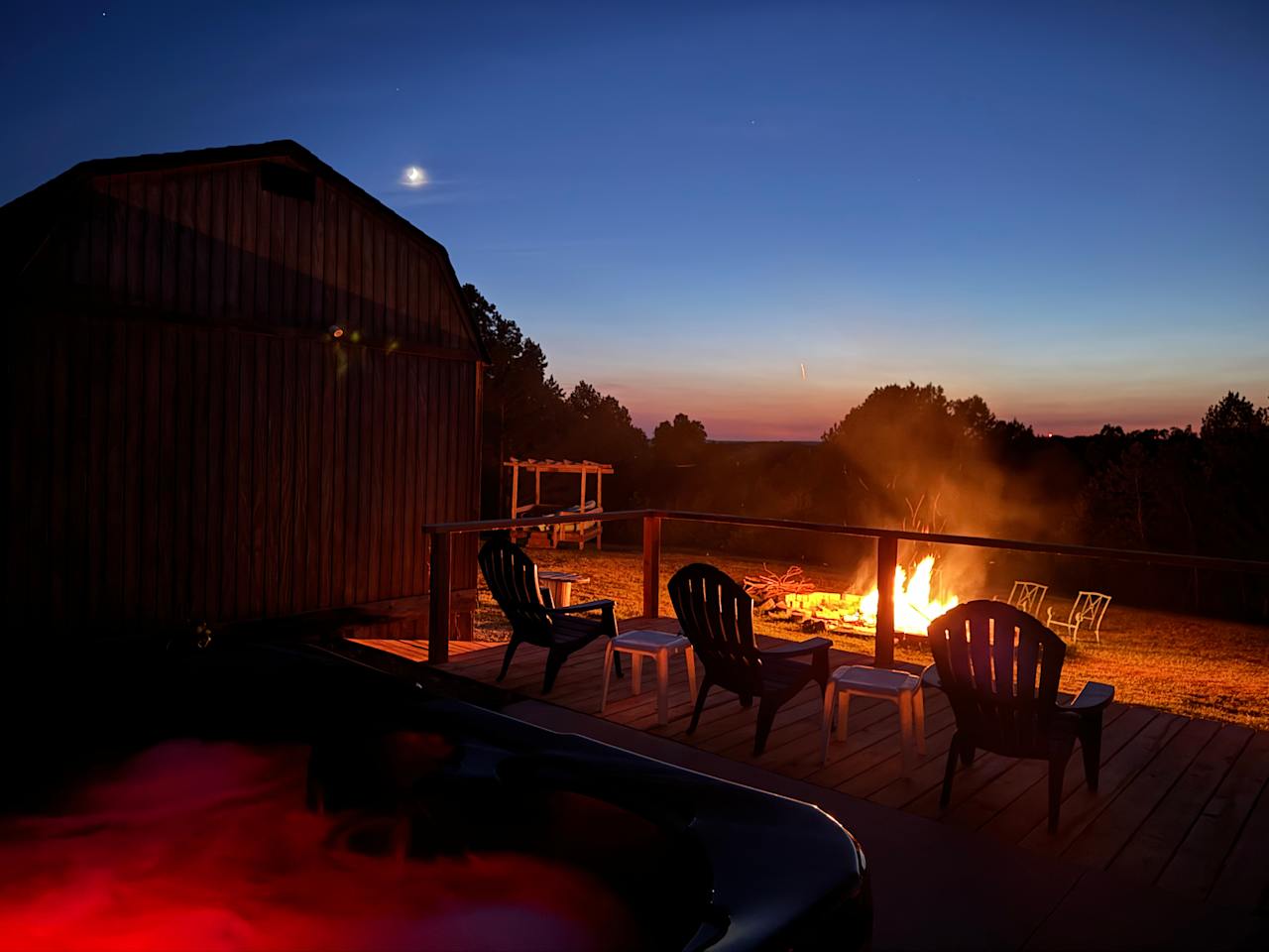 The hot tub sits on a concrete patio that is adjoined by a 27’x8’ deck with plenty of meeting space overlooking the firepit and stage. 