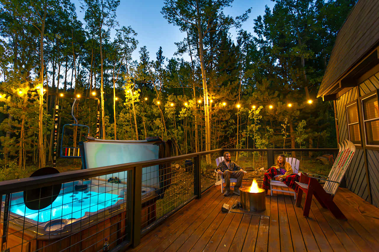 Patio with solo stove and seating, lights come on at night and hot tub 