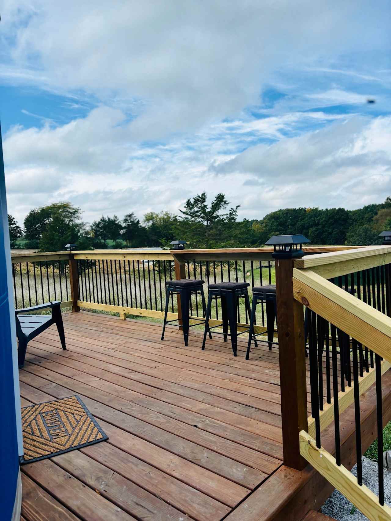 Outdoor deck with Adirondack chairs and bar rail for outdoor eating.