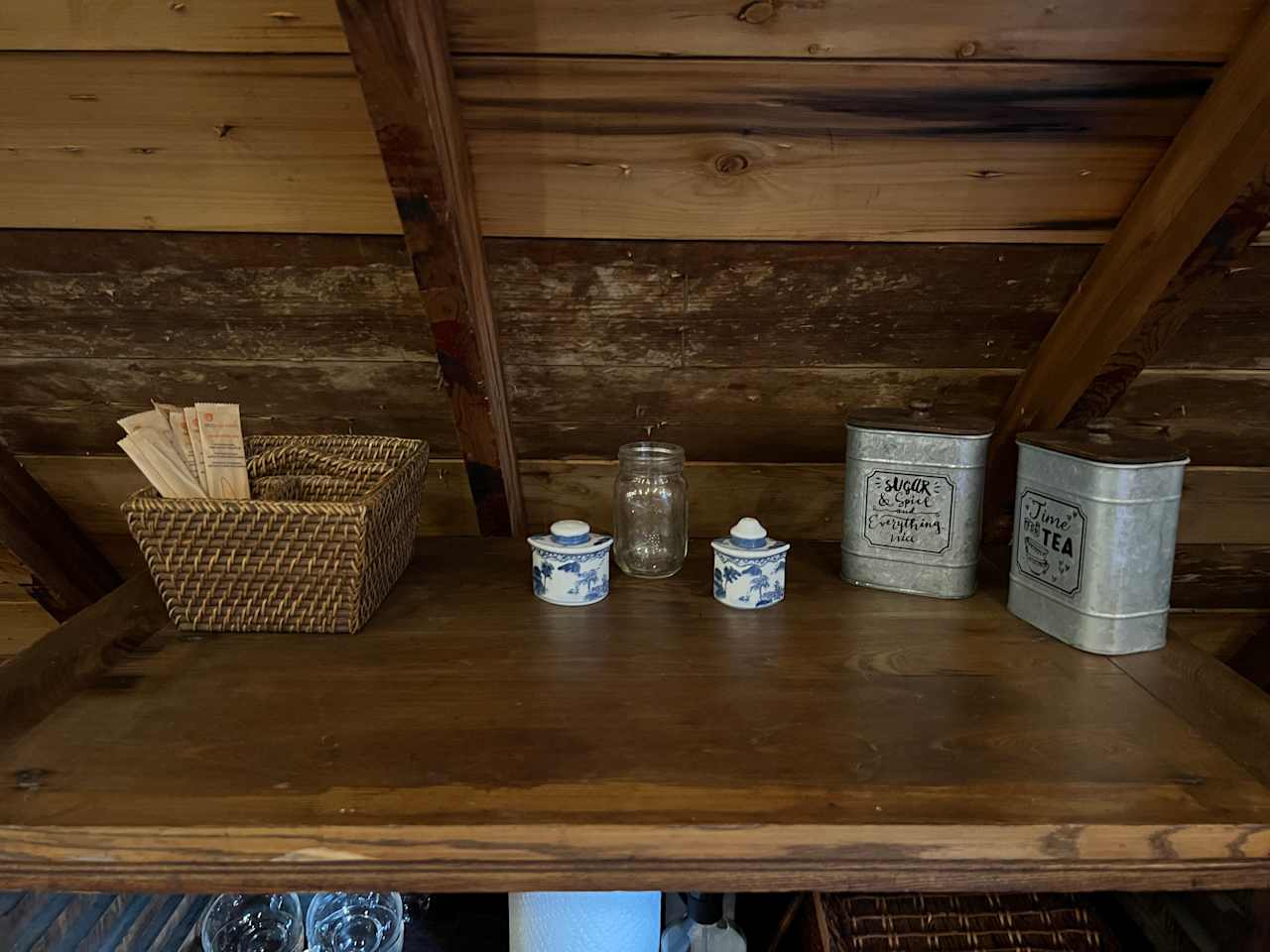 A dining credenza with cutlery, plates, spices and tea. 