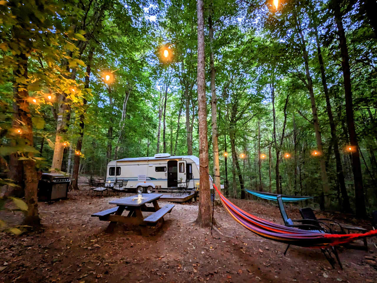 Camp in comfort in an enchanted forest! Enjoy the RV, 6-burner propane grill, lighting, and all that you see in the following photos!

Have a big group? There's plenty of room around the camper for tents. We also rent out tents, sleeping pads, etc.