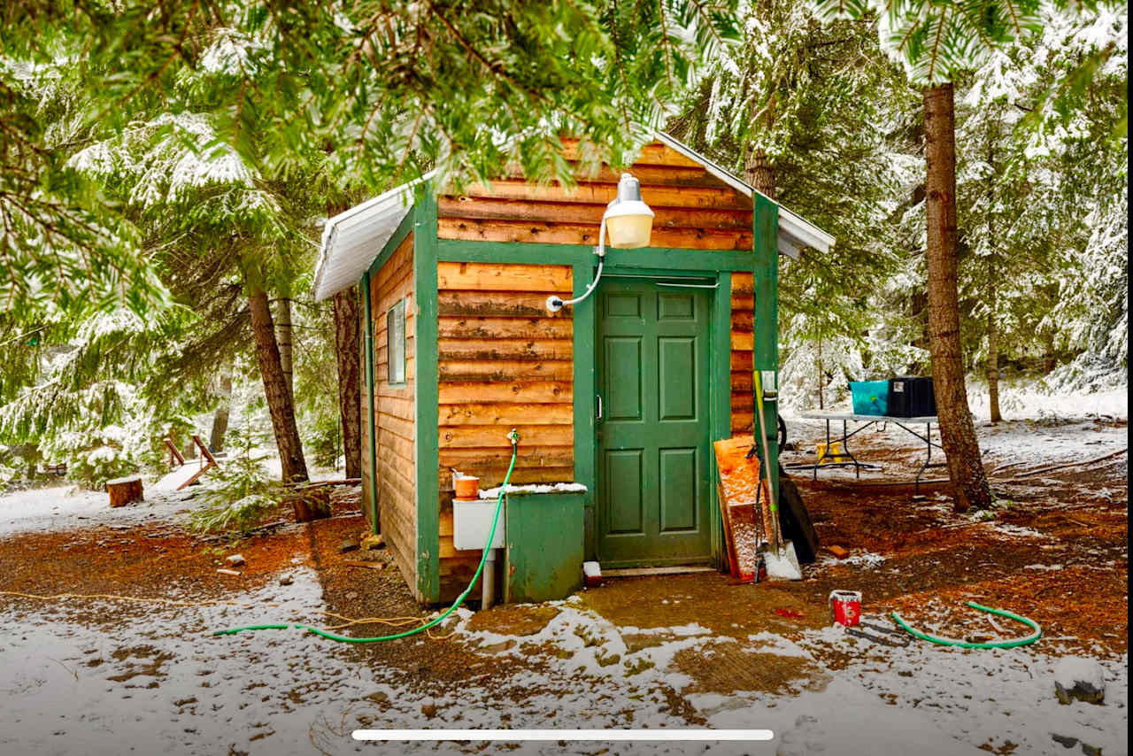 Here's the wellhouse (with a flushing toilet and water + electrical hookups) in front of which you'll back in IF you're in a 20-25ft vehicle, or smaller.

If your vehicle is larger than that, all good!  Simply pull in by the firepit and you'll still have access to these amenities.