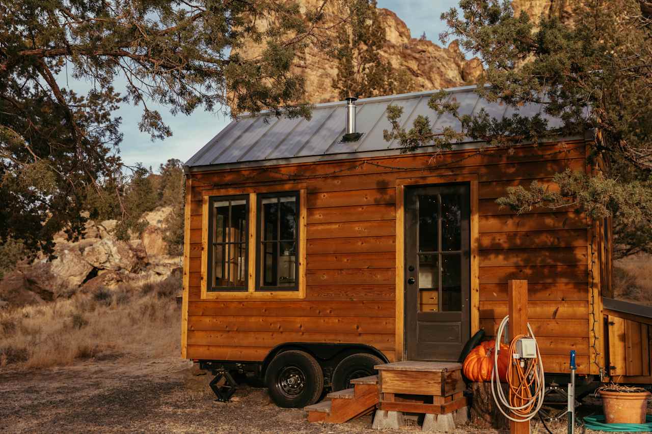 Outside of the tiny home with tuff boulders as the backdrop.