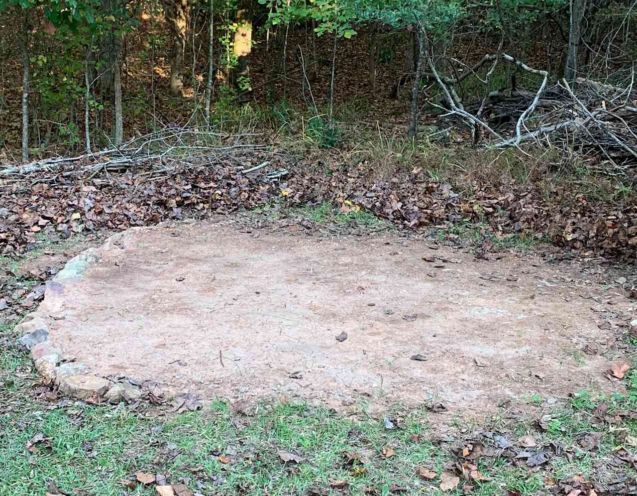 Close up of first tent site option - leveled dirt area bordered with rocks