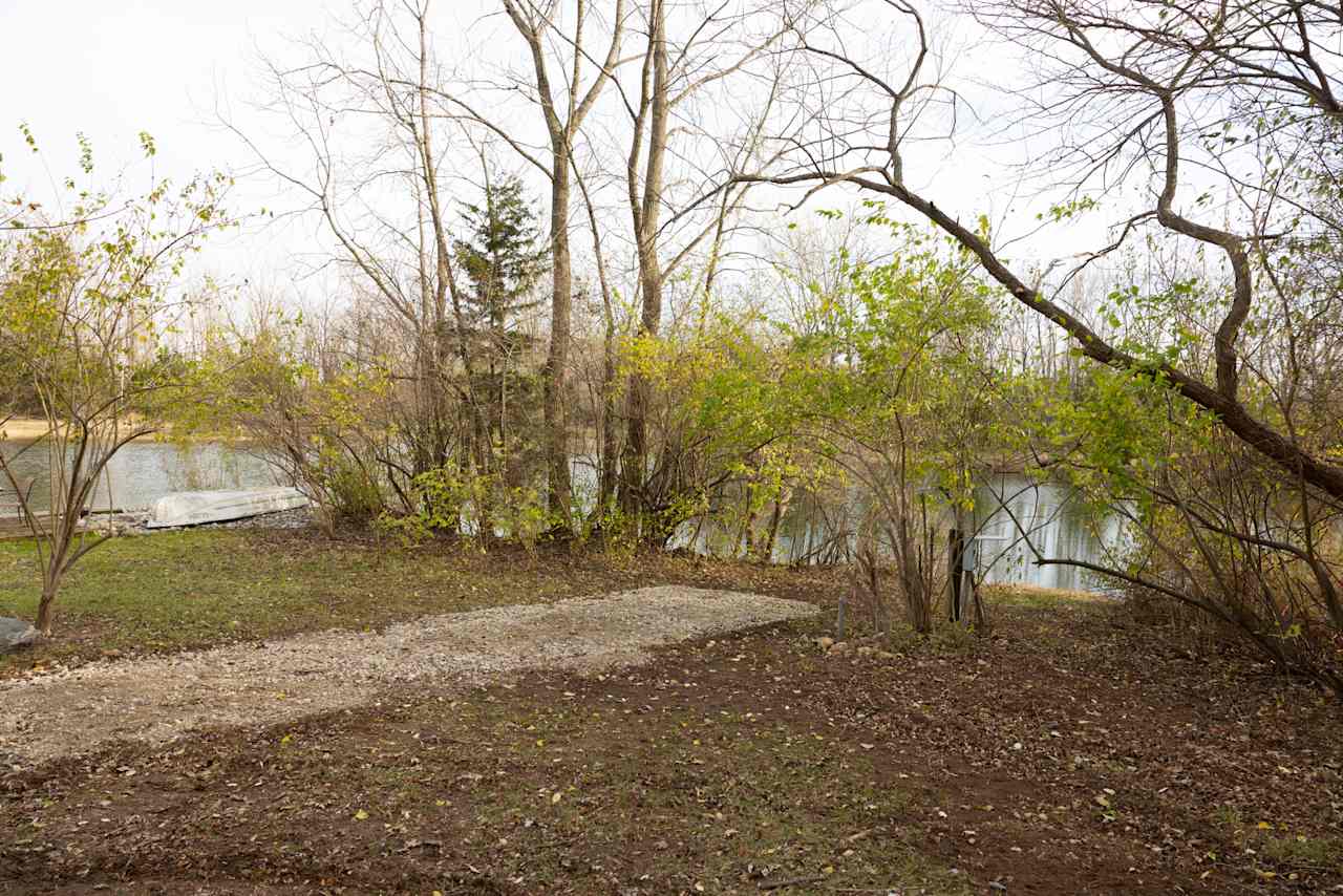 Cattail Springs Site #2. Waterfront location situated at the bottom of the hill facing southeast. Ease of access to fish (catch and release), fire pit, dining area and more. 