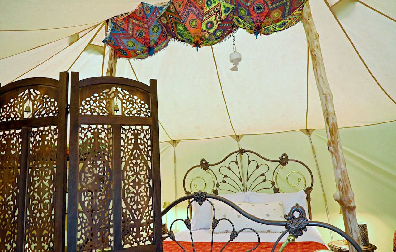 Inside the Bombay Belle cottage's 5'9" walls and under its 8'6" ceiling, you can really stretch out and spread your wings. The intricately scrolled queen-size bronze bed is the centerpiece of your suite.