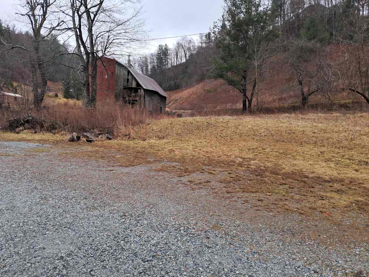 View of the gravel driveway site. Lovely grassy area behind, BUT (see next photo)