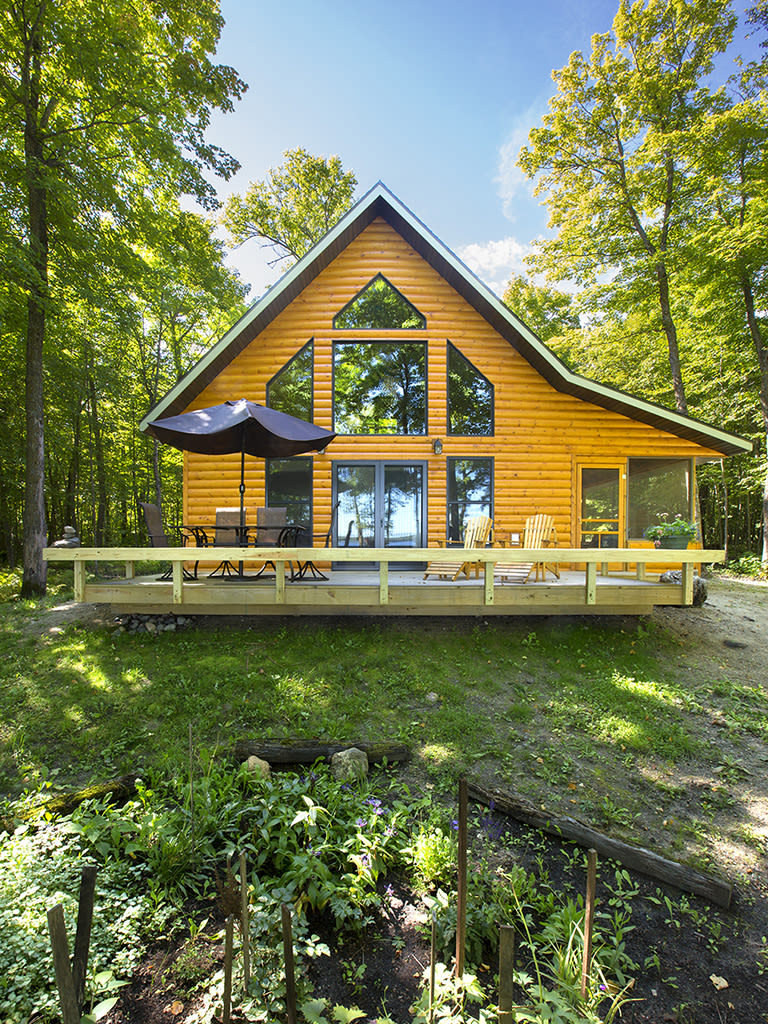 Cabin with cathedral windows and front deck.