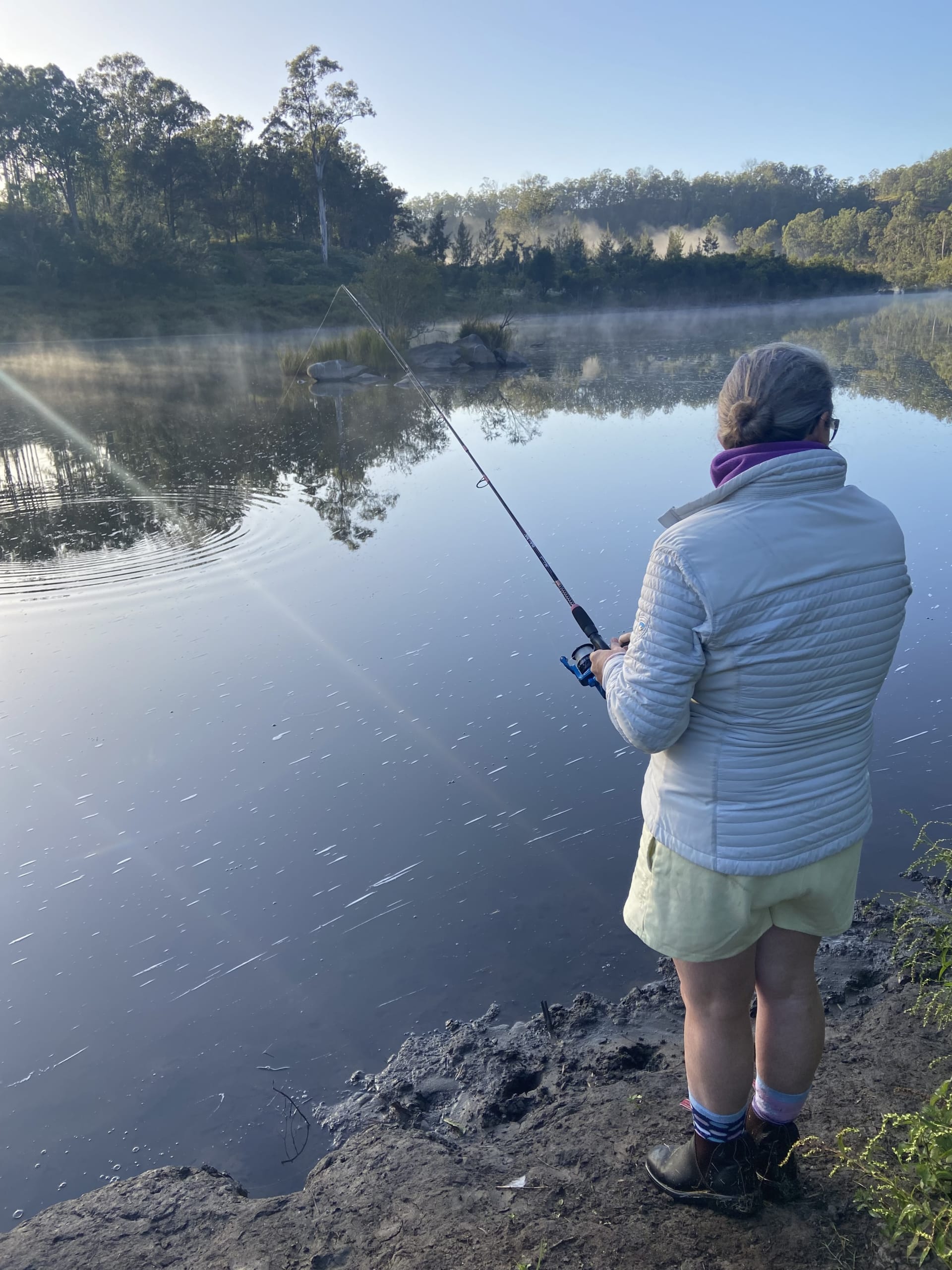 Man beach fishing with fishing rod standing on reef at Guilderton