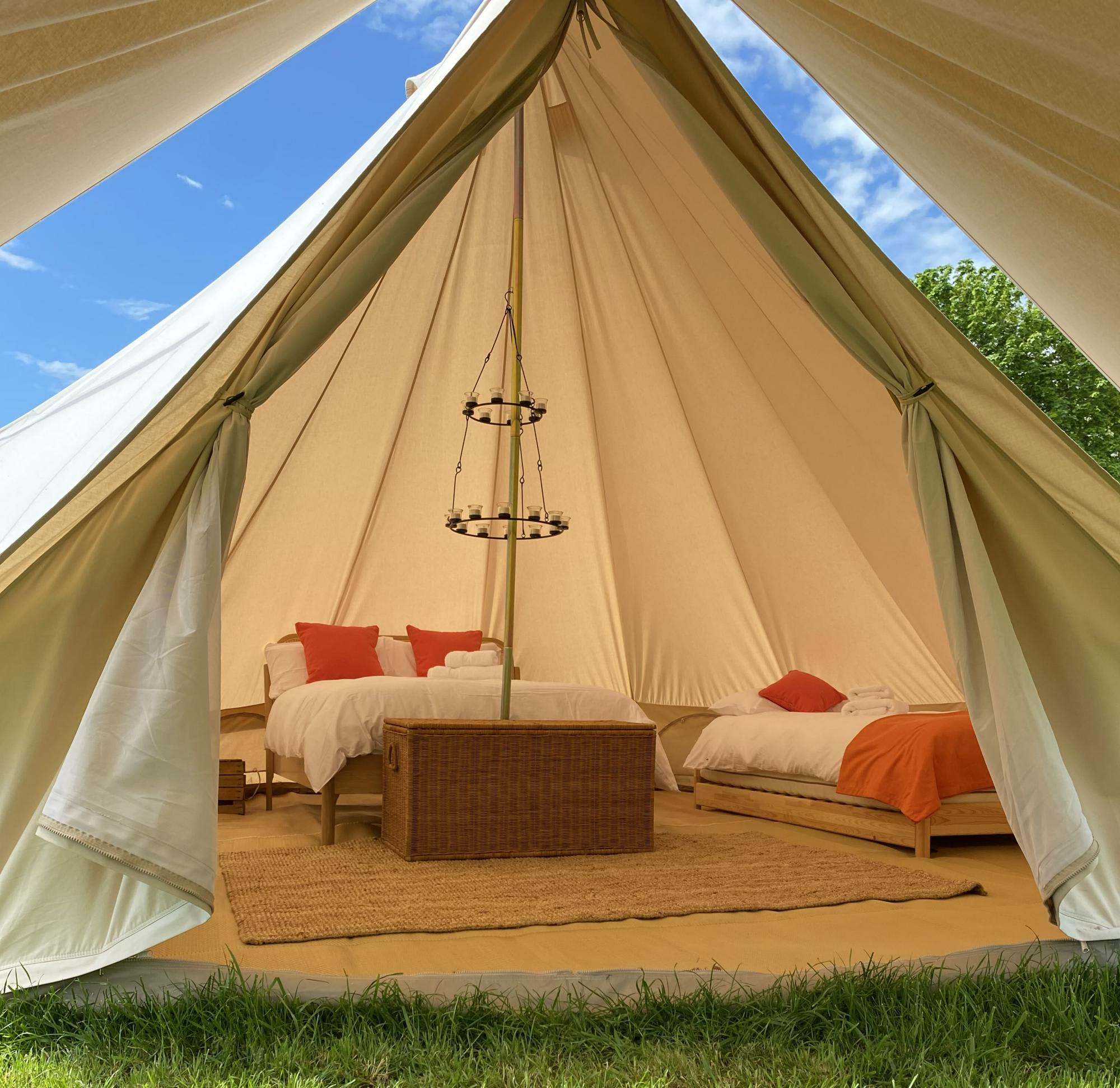 Bell Tent - Mimi, each of our bell tents has a double bed and an option of two single beds. Fresh linens and wood burner make this a luxe stay.