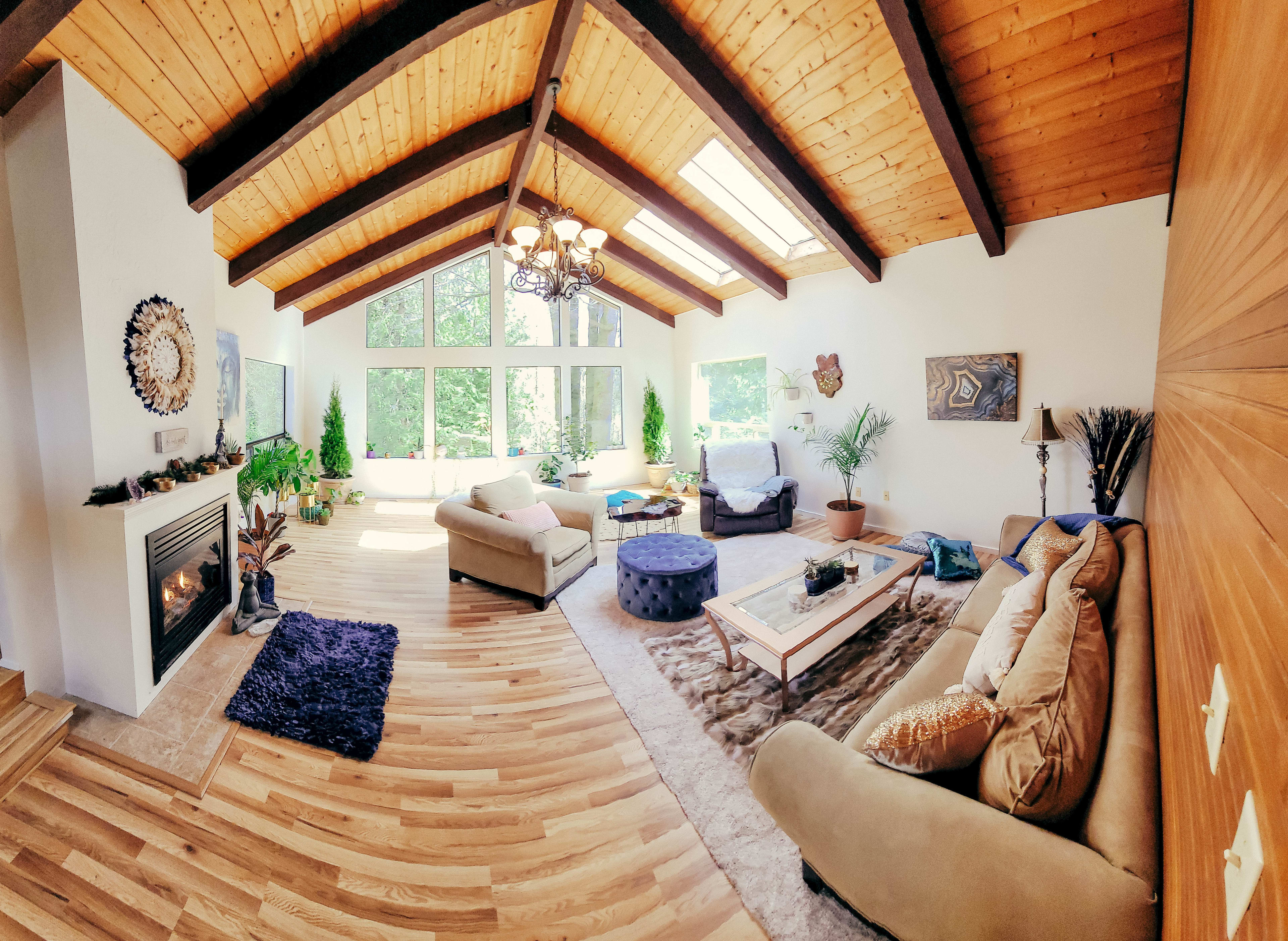 Great Room Sanctuary with forest views! Skylights, indoor trees, plants, meditation space, propane fireplace, singing bowls, and a custom crystal embedded redwood table!