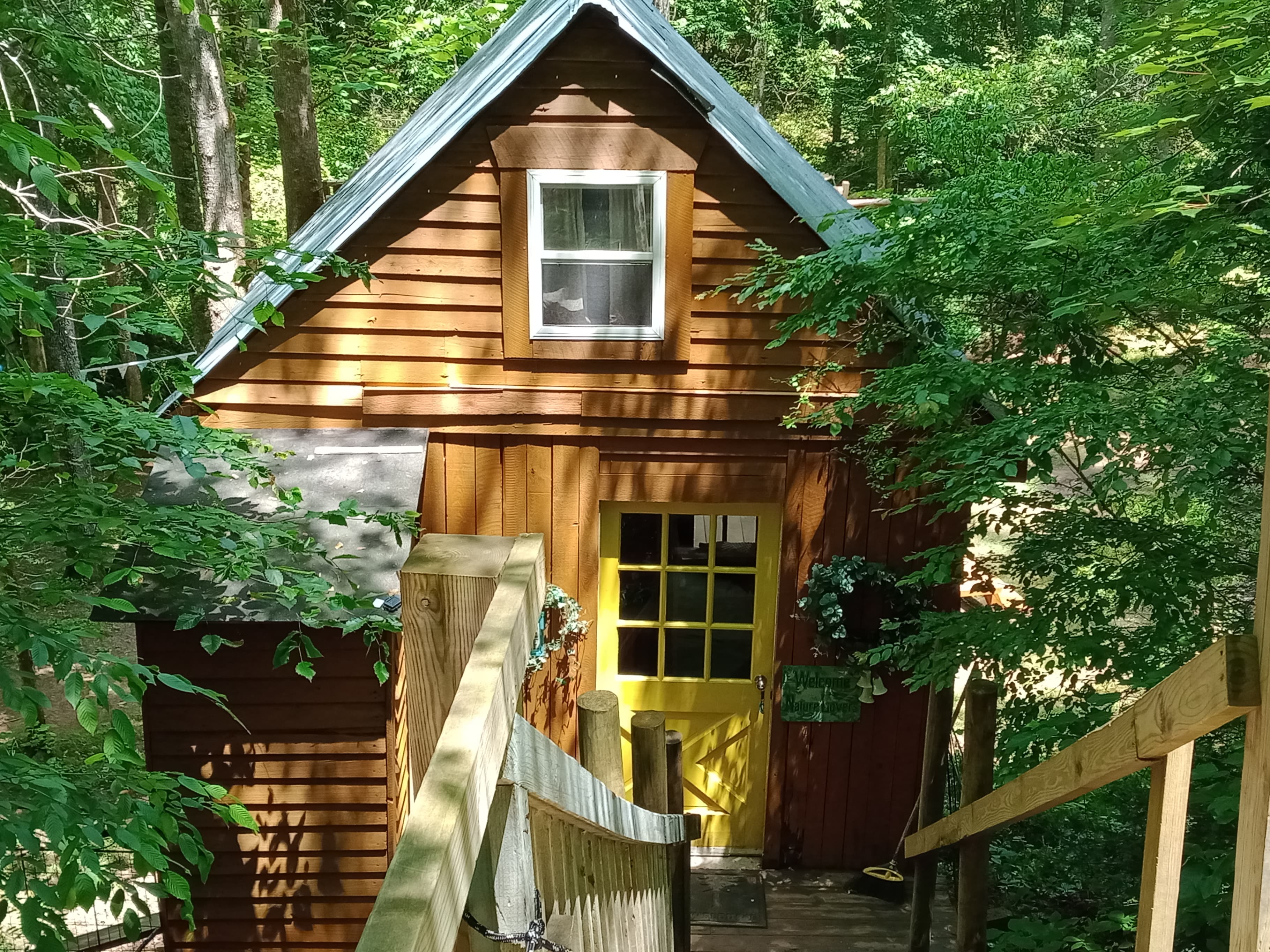 The front door of the treehouse. The interior is 12x12 with a loft bed, queen, and a deck facing the creek. The deck has an awning to protect you from rain. 