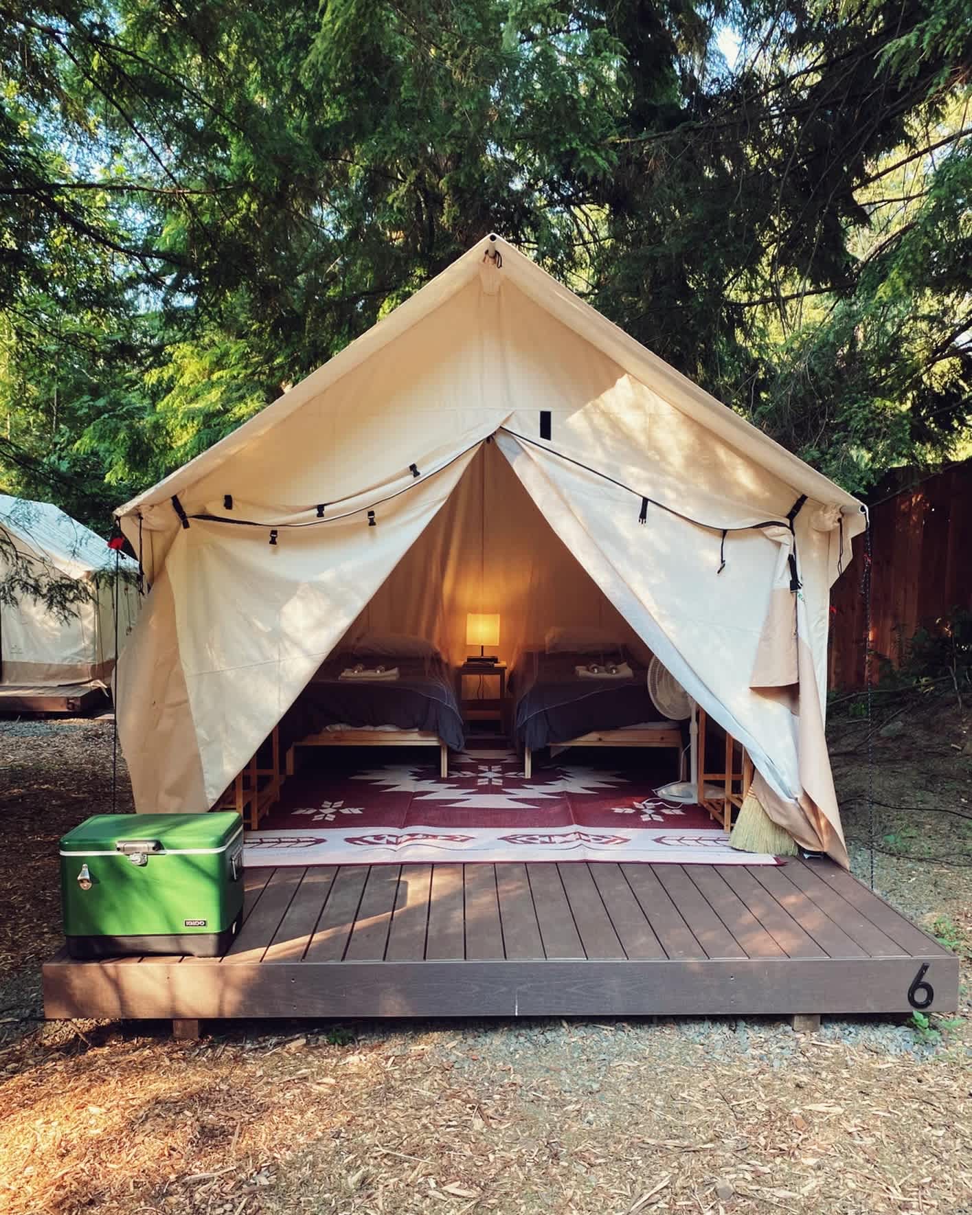Luxurious platform canvas wall tents feature wireless phone chargers, high thread count sheets, and boot dryers.