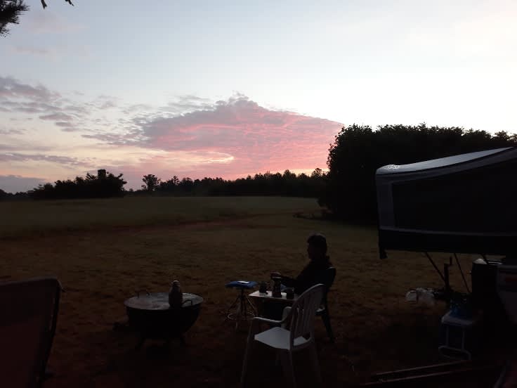 Having coffee in the middle field at sunrise