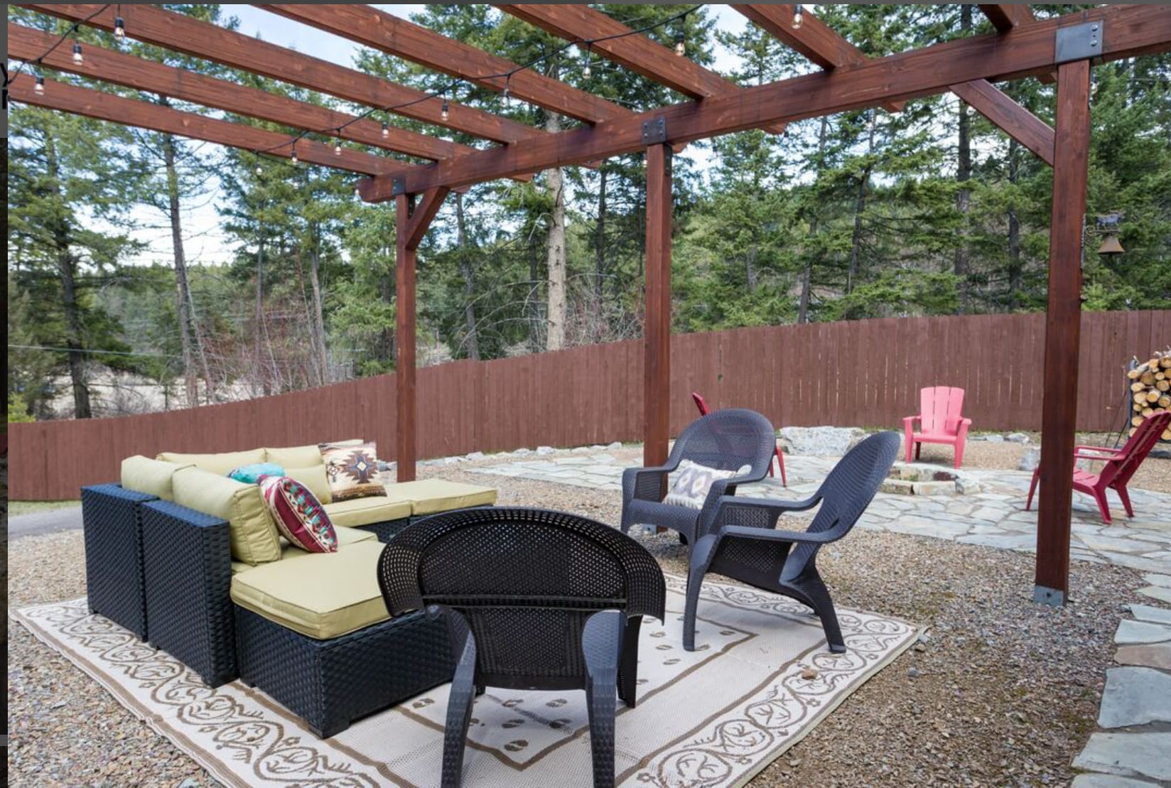 Lit up pergola next to firepit, grill available