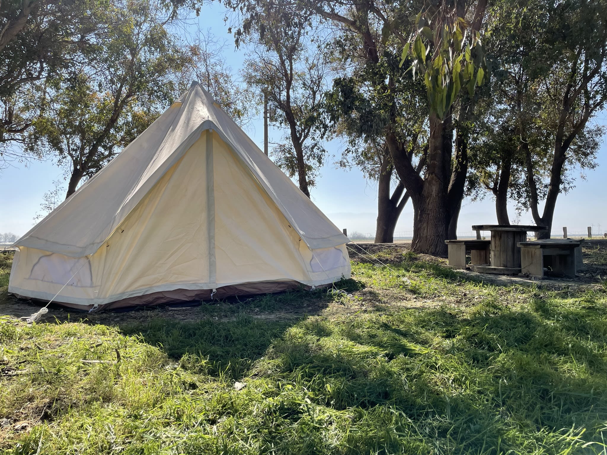 Campsite includes canvas tent, picnic area, fire pit, potable water spigot and trash can