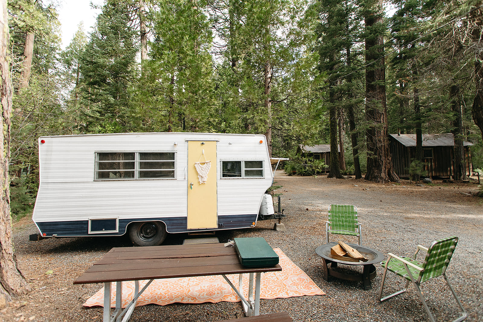 Outside of the trailer featuring table, chairs, fire pit and camp stove