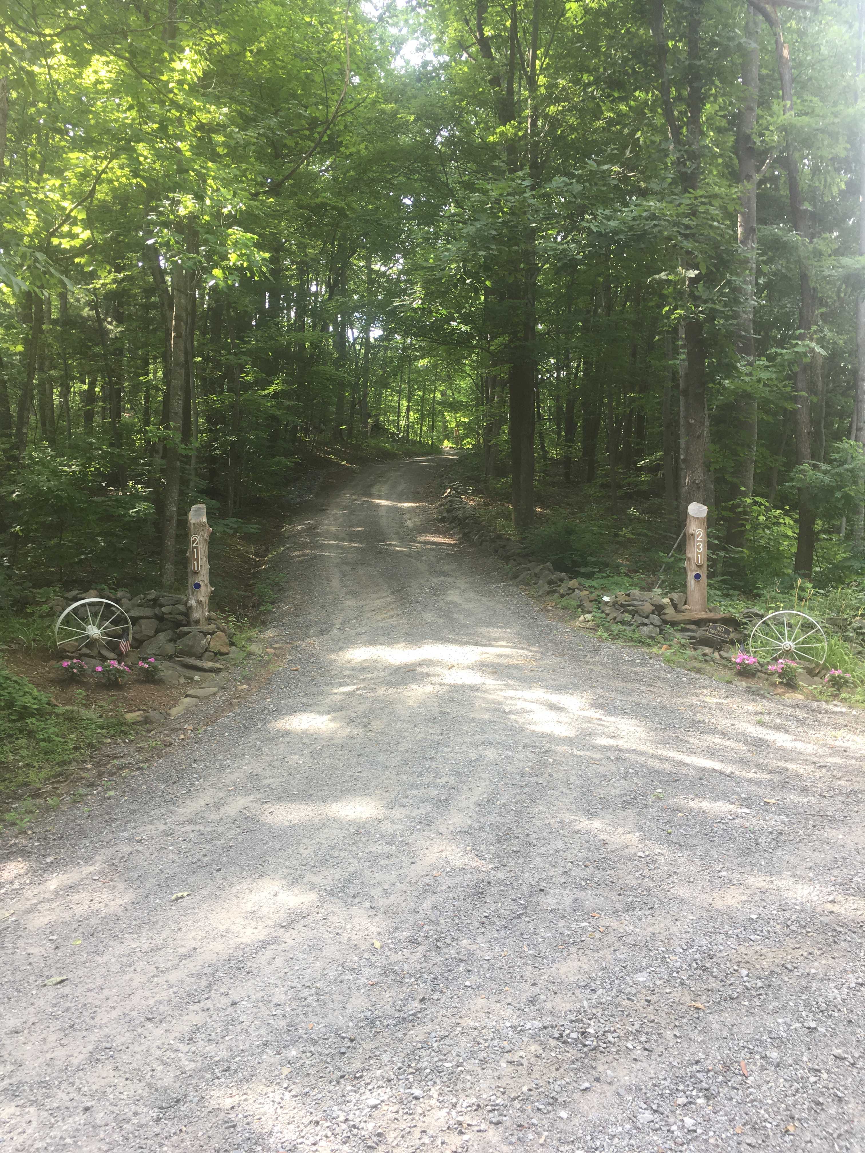 After turning R onto Park Drive, keep an eye out for this sharp L turn at the white wagon wheels. If you miss it, turn around in our upper driveway.  
