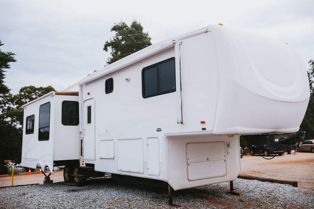 Outside view of fifth-wheel camper located in a gravel campsite at Big Water Marina & Campground,