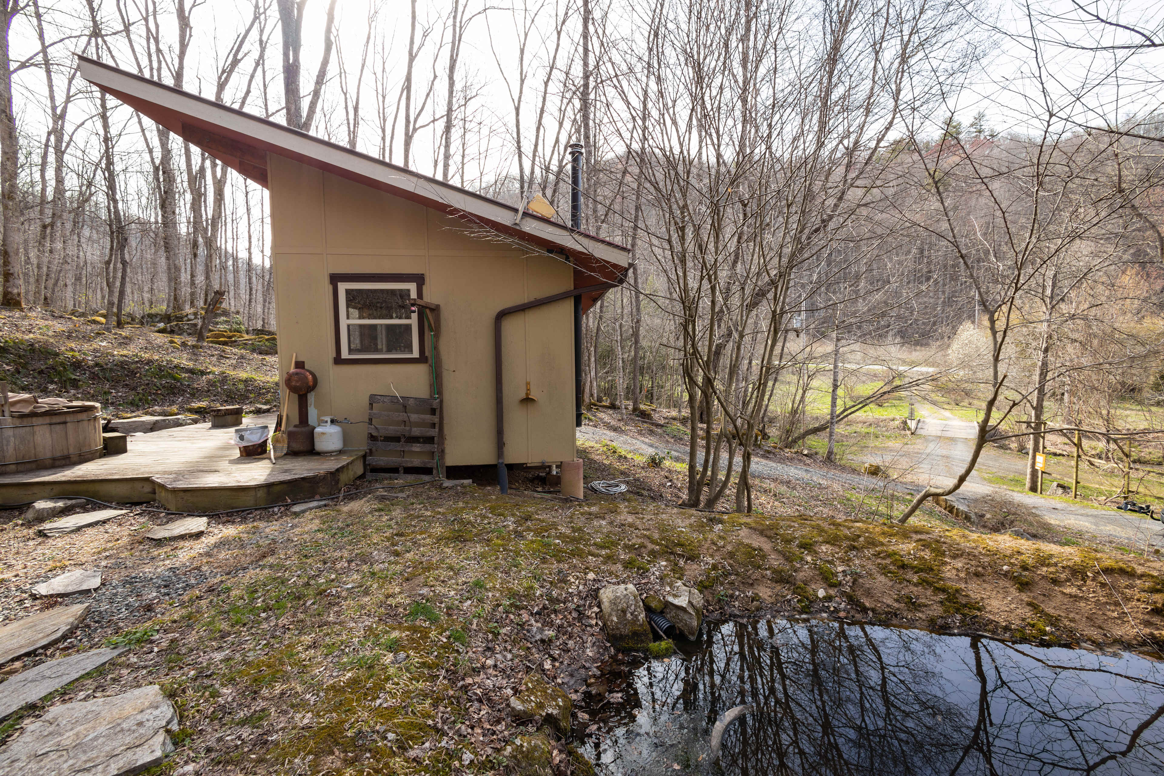 There is a small pond beside the tiny home.