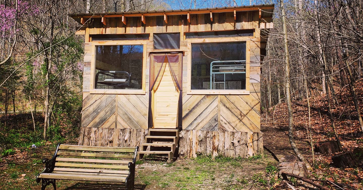 Simple, 1-room bunkhouse made with salvaged wood, doors, and windows.