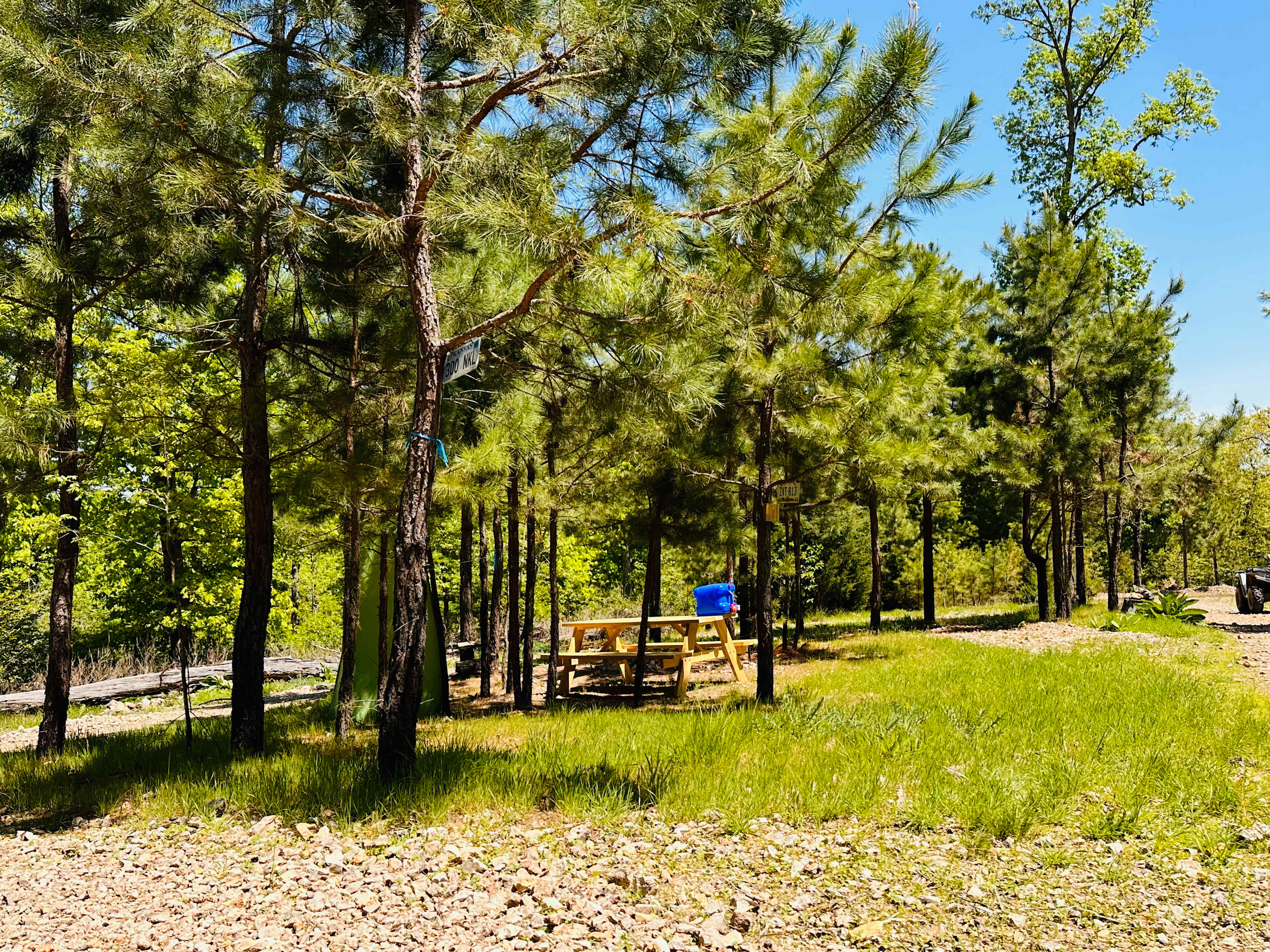 Site #1 complete with bathroom tent, picnic table, and 5 gallon water jug.
