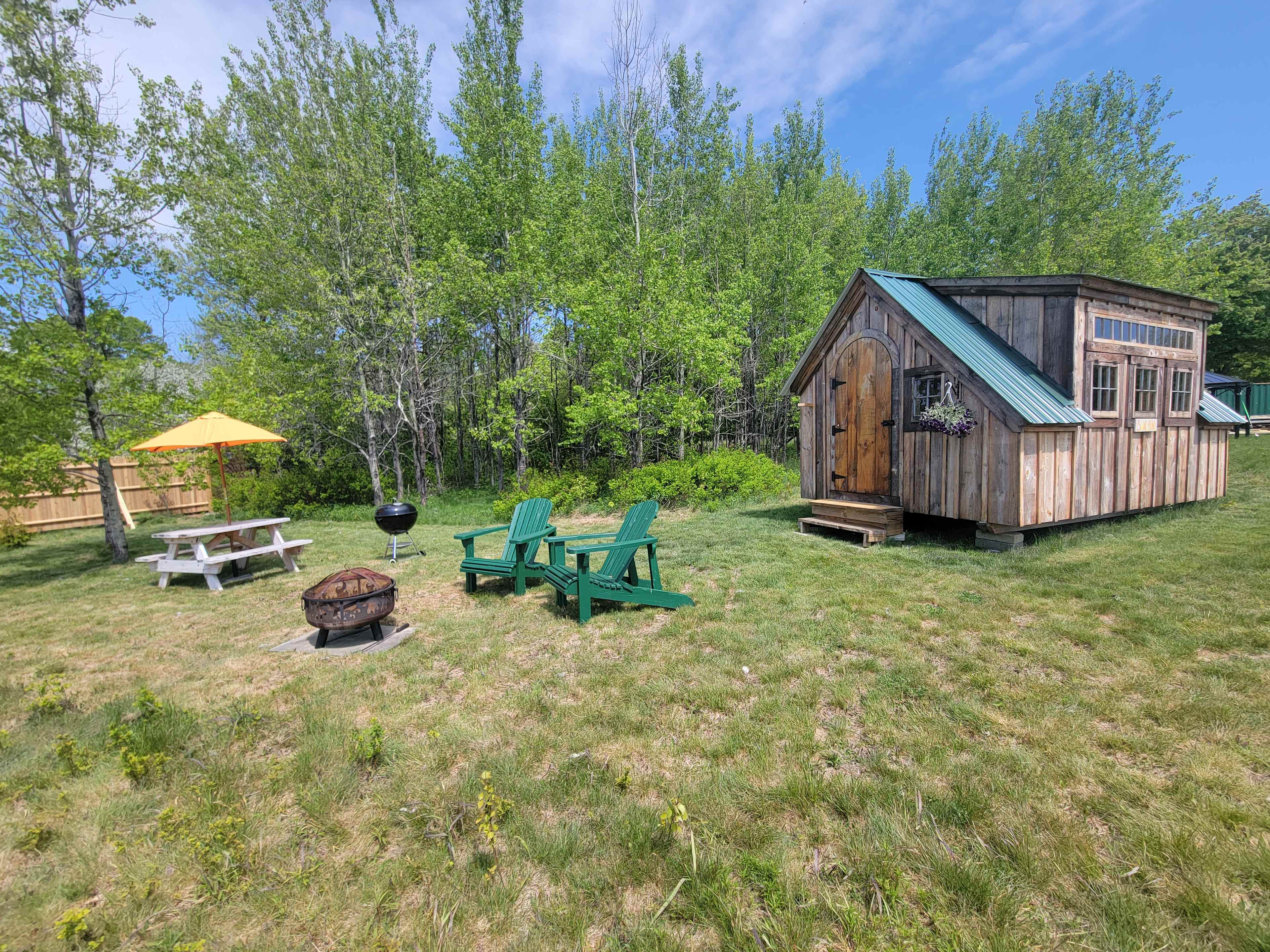 Site includes picnic table with umbrella, charcoal grill and firepit. Hammock and two Adirondack chairs 