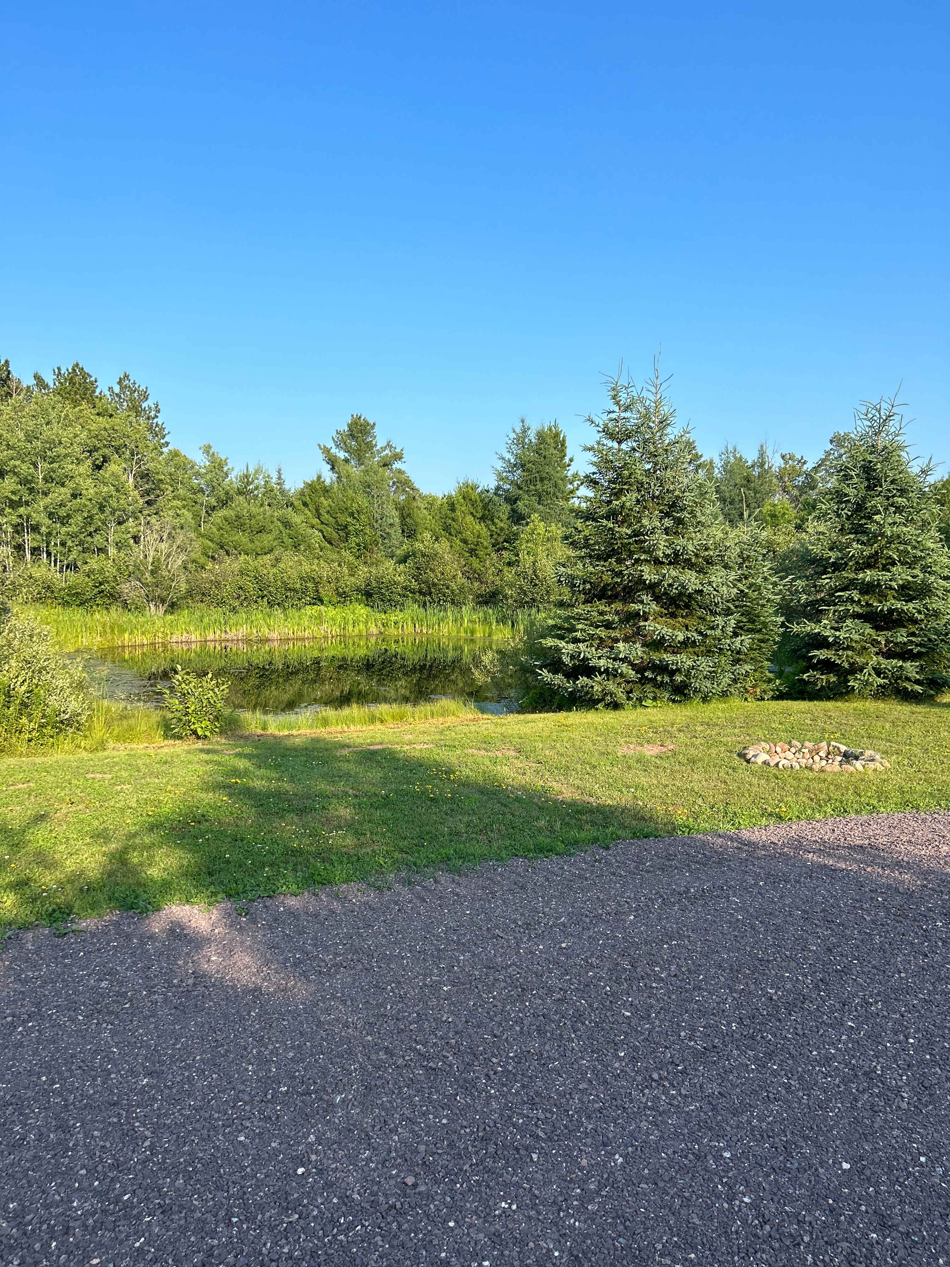 Pond, fire pit, and part of gravel pad.