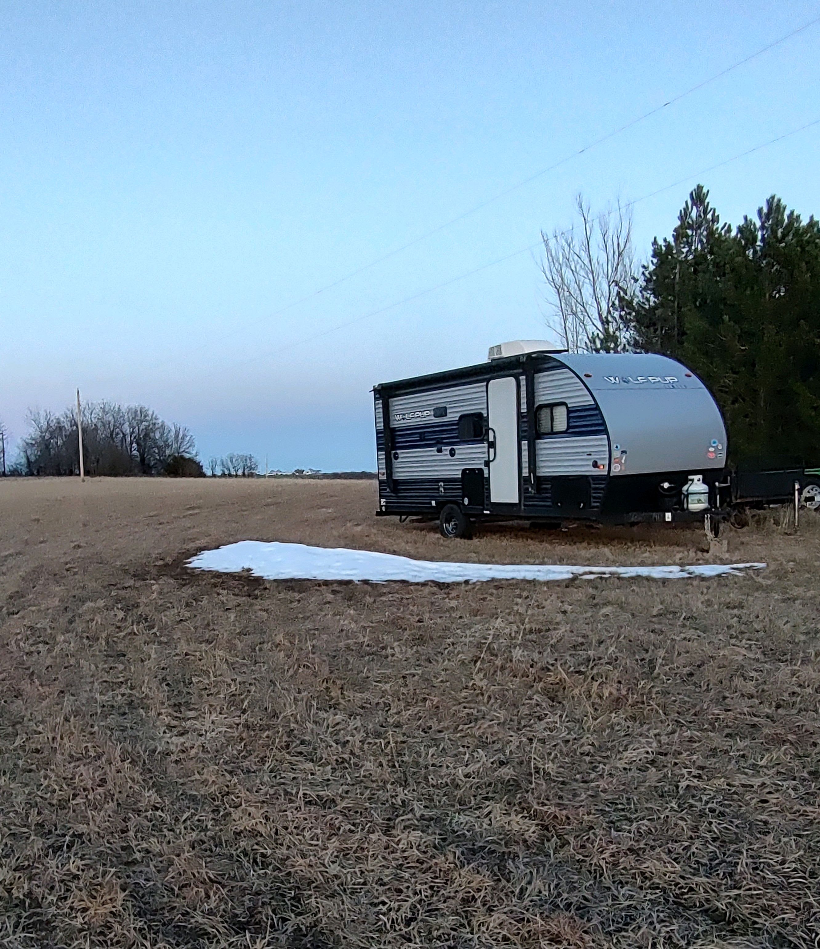 Additional area behind tree line for setting up tents.  Camper will be rented and moved to driveway area.