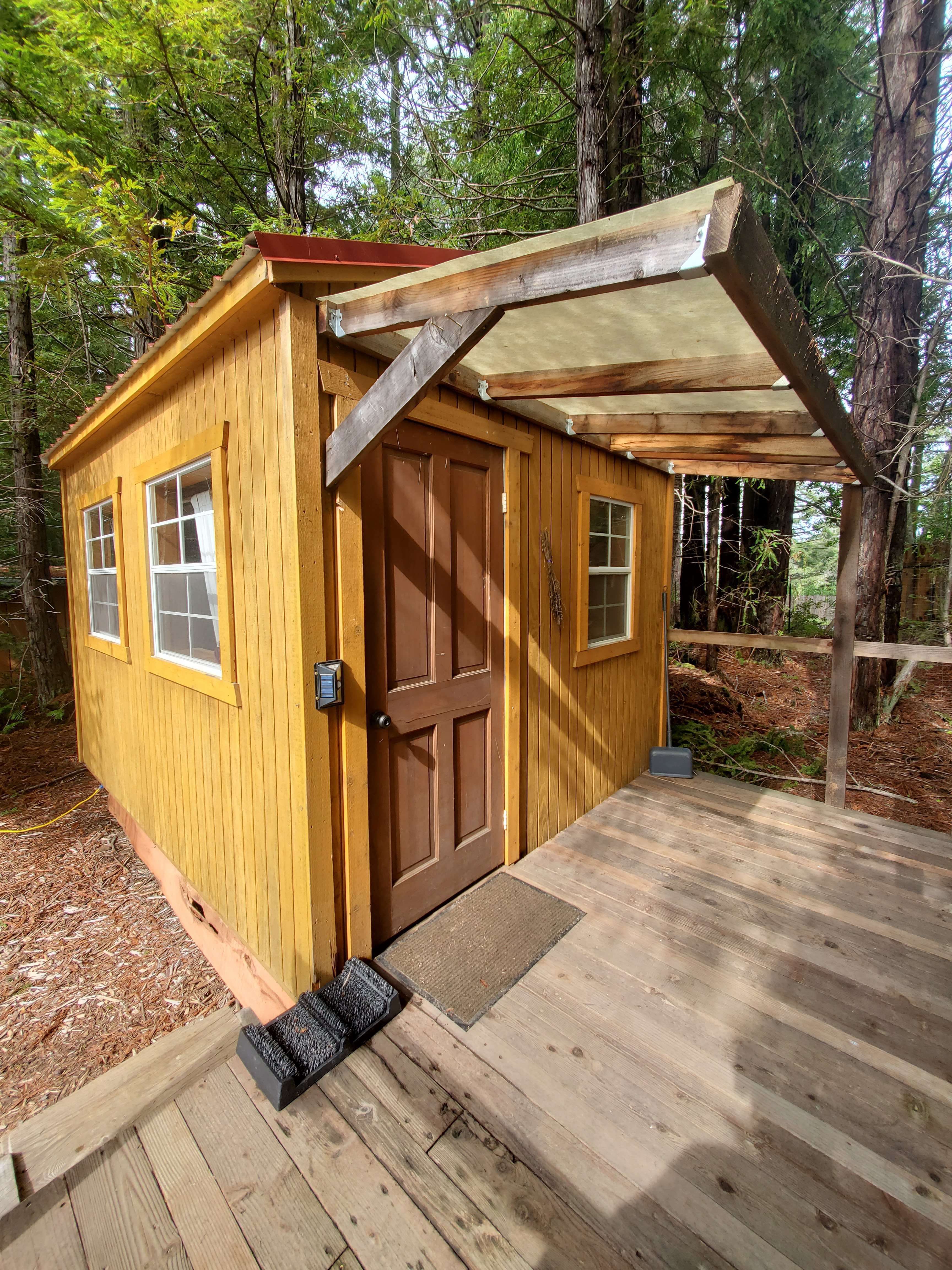 covered porch is a great place to listen to the birds and enjoy the sunlight coming through the trees