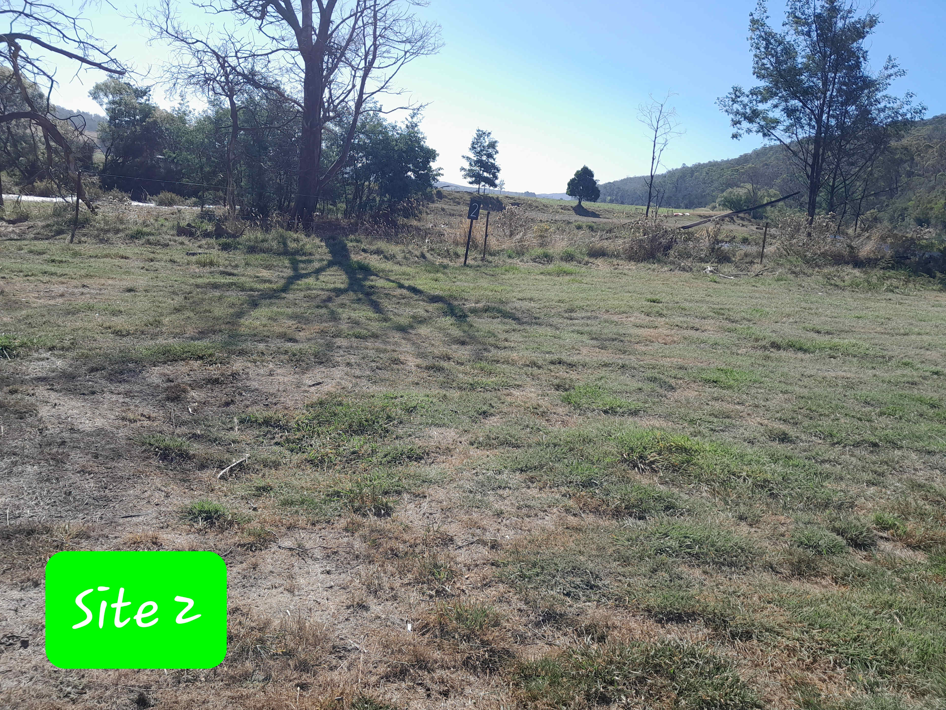 Site 2 river is behind over the bank, little bit uneven but lots of space