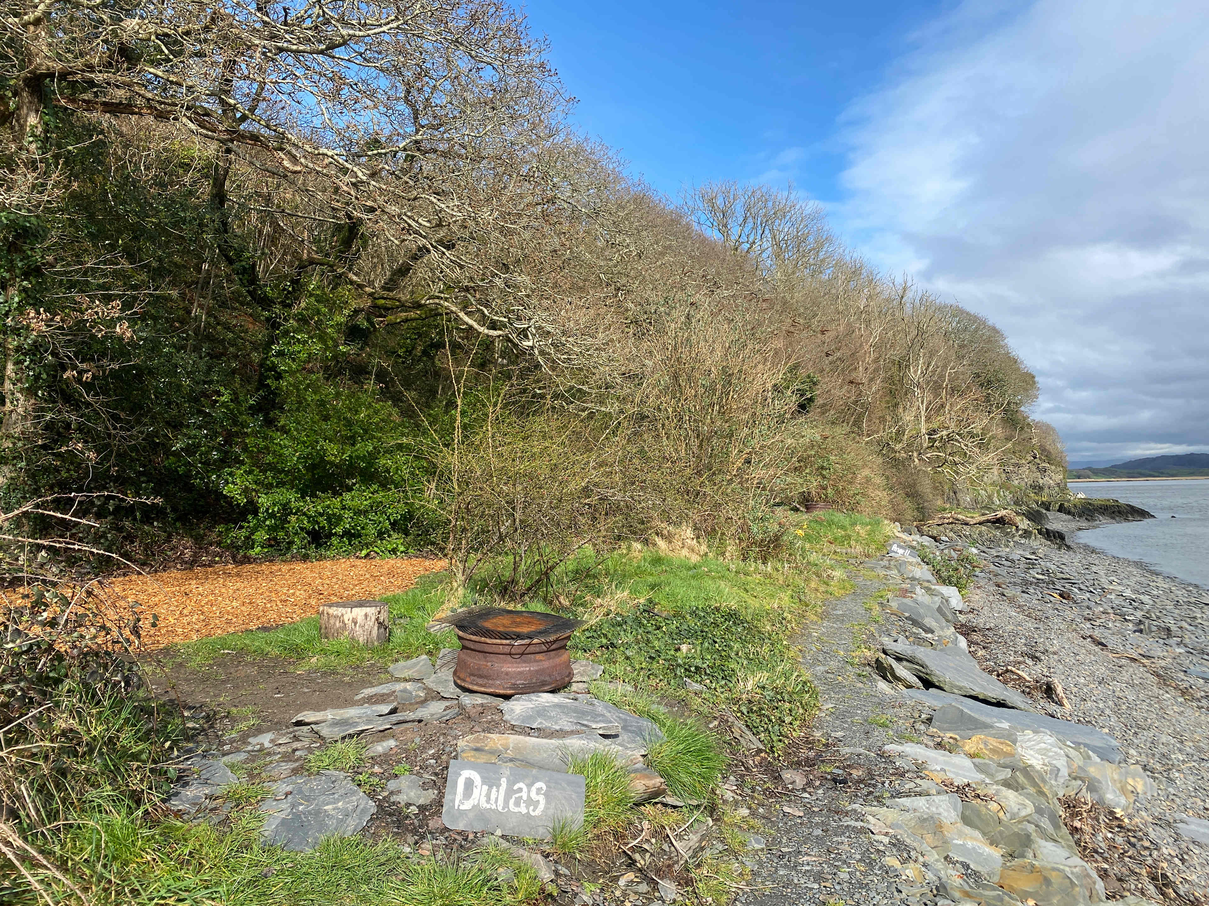 The pitches sits on a raised slate plateau, nestled under the treeline...separated from the other pitches by shrubs... (picture taken in early spring before a lot of the green leaves have grown back after winter!)