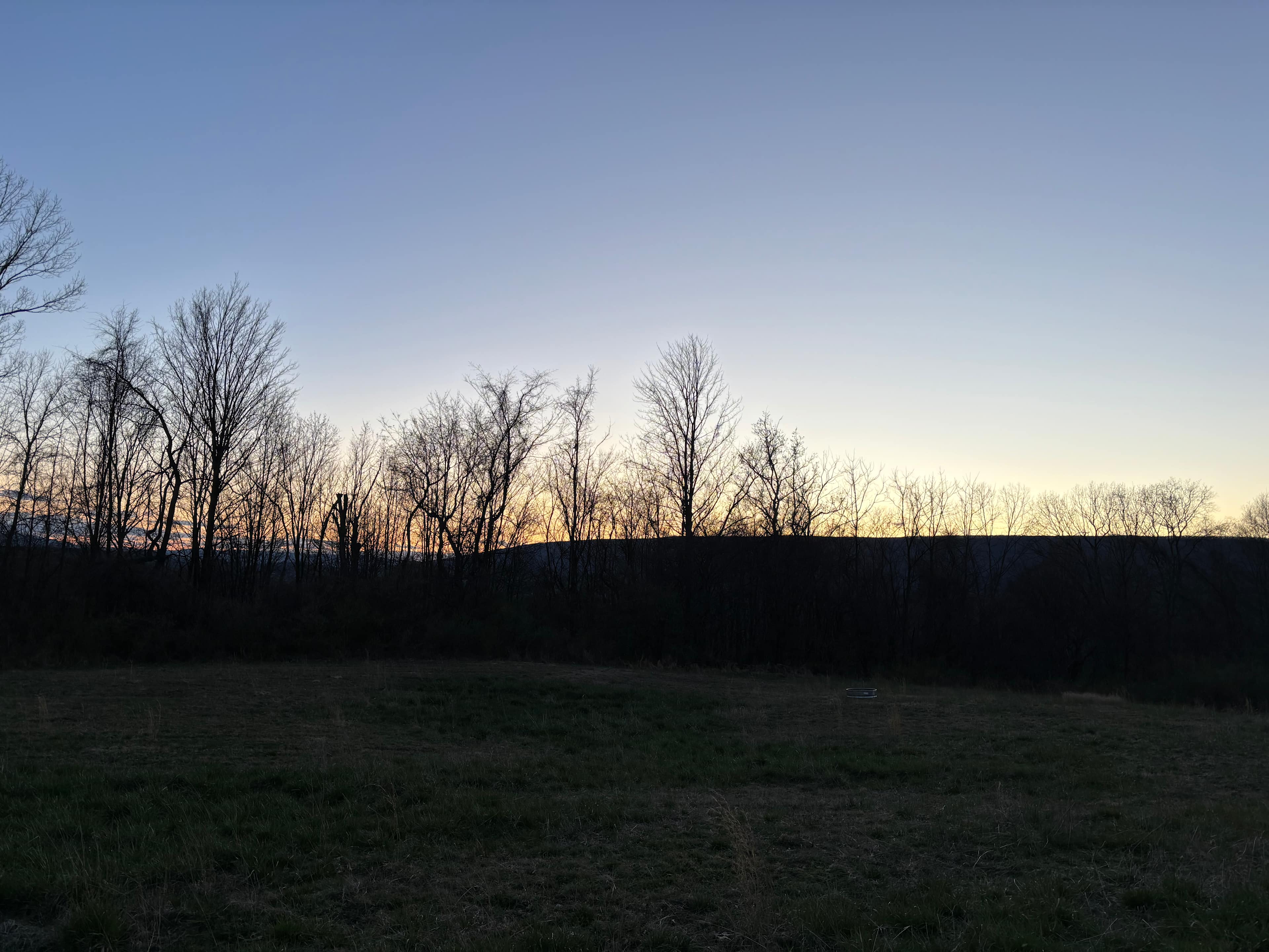 The sun sets over the ridge to the west of the lake.
