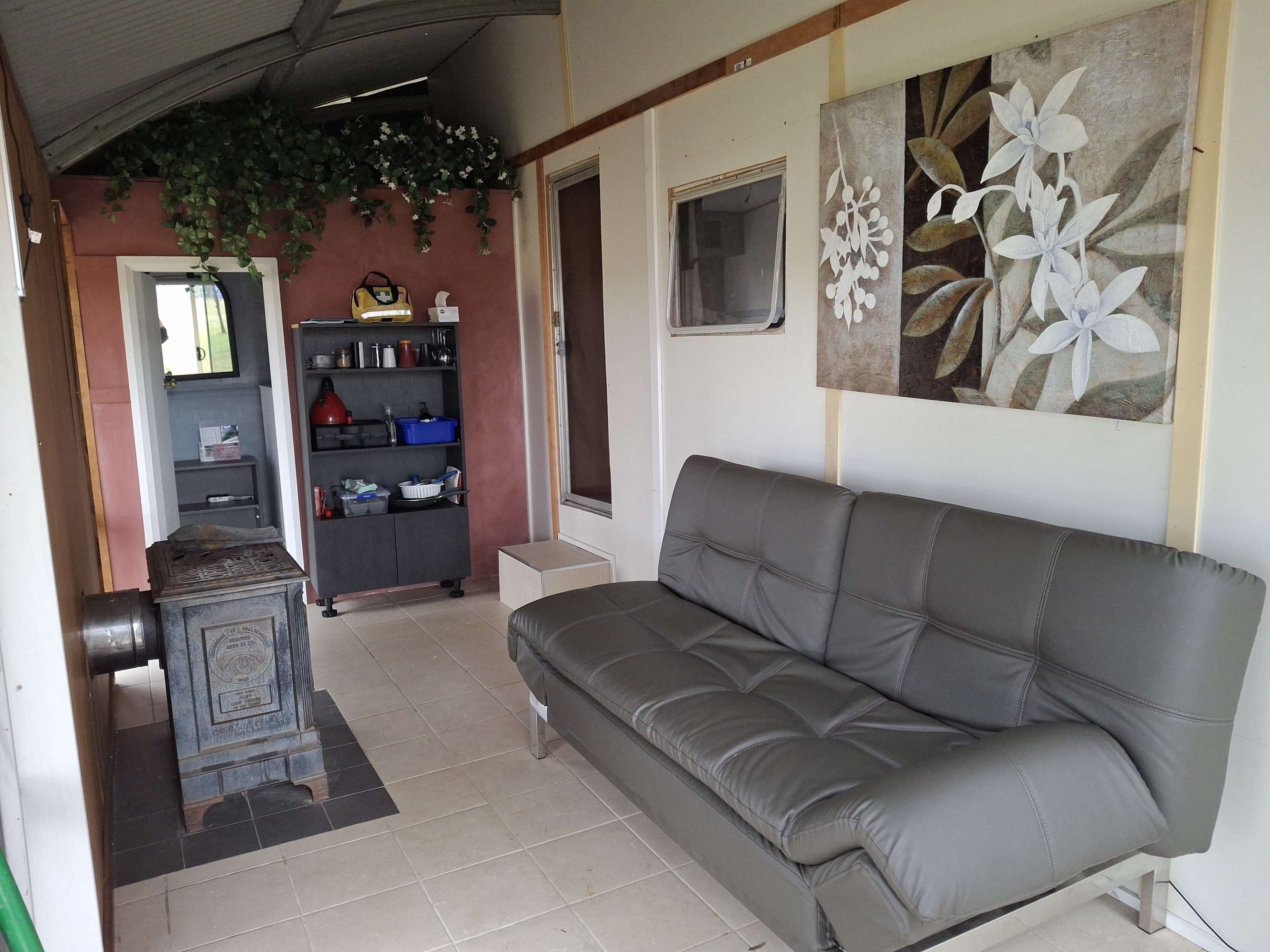 Fold out lounge in annex area with fireplace and cabinet with crockery, cutlery, washup basin, gas cooker, kettle, fry pans, etc.