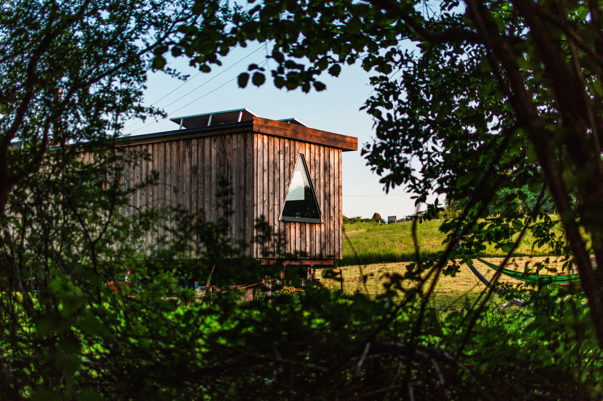 A view of the cabin and the spectacular triangular window from the woodland 🌳