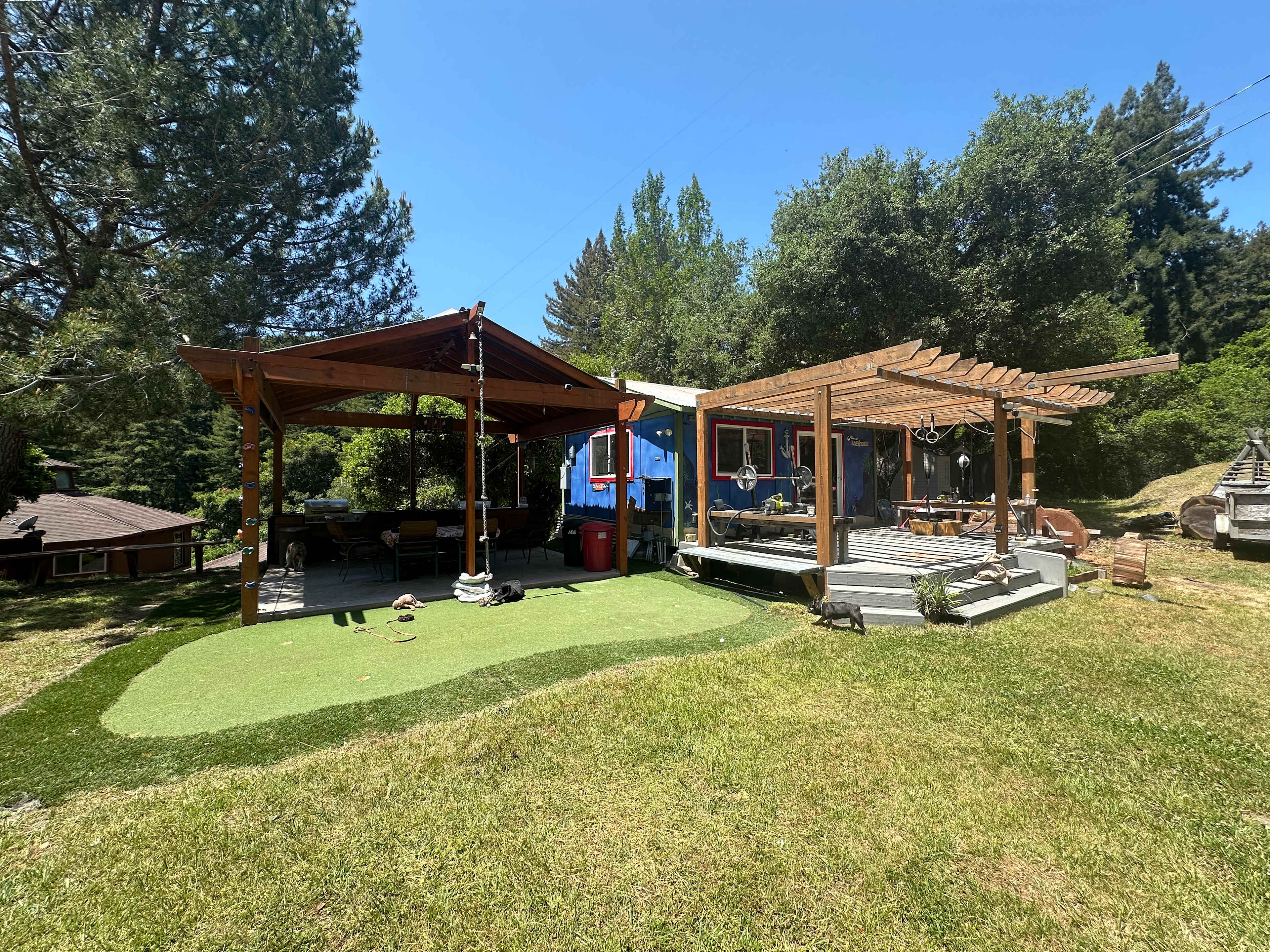 The bungalow has a porch outside along with a covered kitchenette and a table with seating for 6. There’s a putting green with clubs and balls and a climbing rope. 