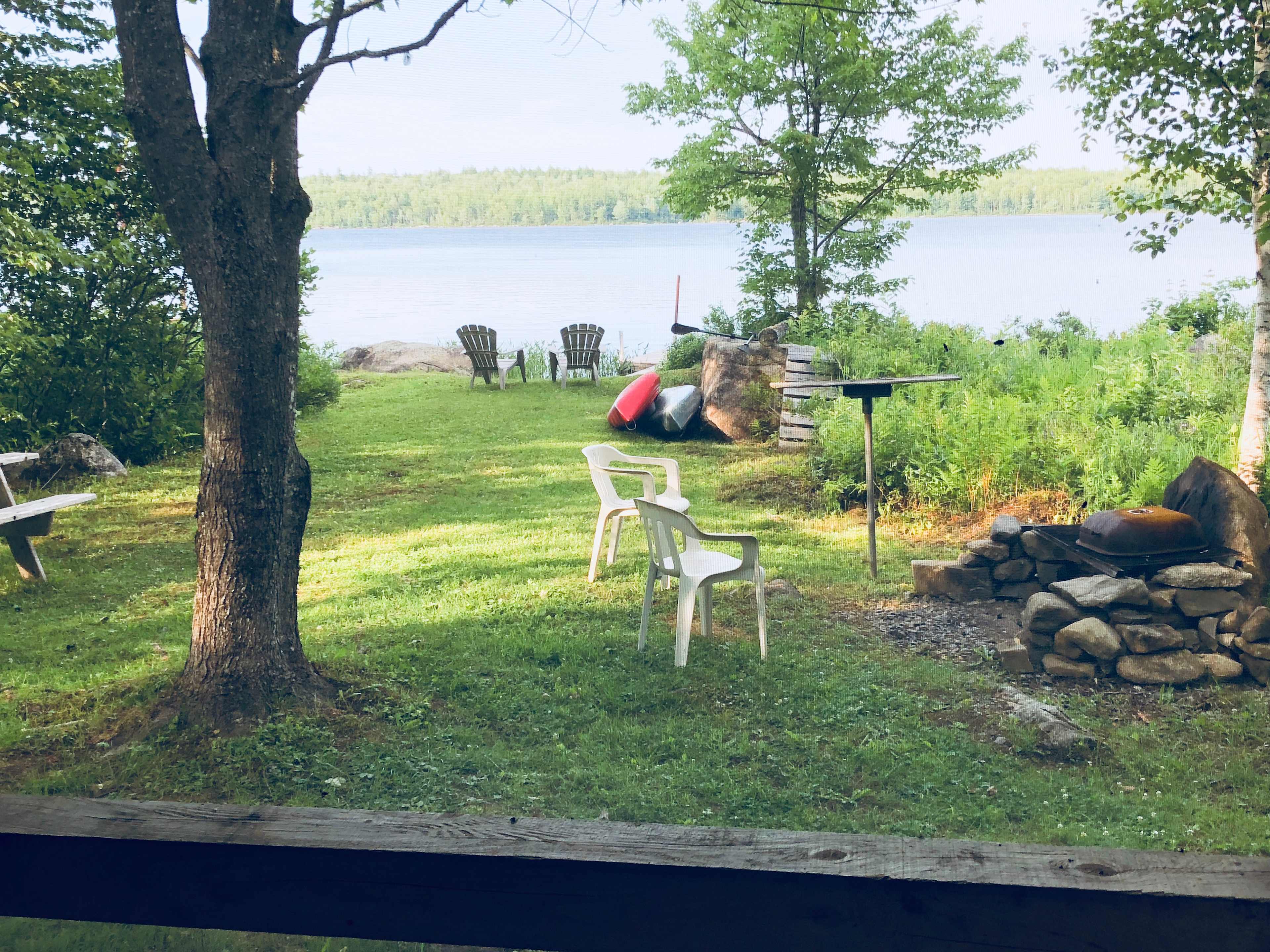 The yard of Trapper Bill's cabin has a picnic table and fire pit with grate for cooking.