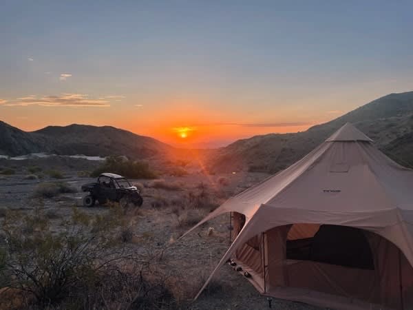 This 8 person tent is super spacious with one queen bed. 
Add additional cots for a fee. 
You could also have two cots instead of the queen bed. 
Parking in front for your off-road vehcile. 