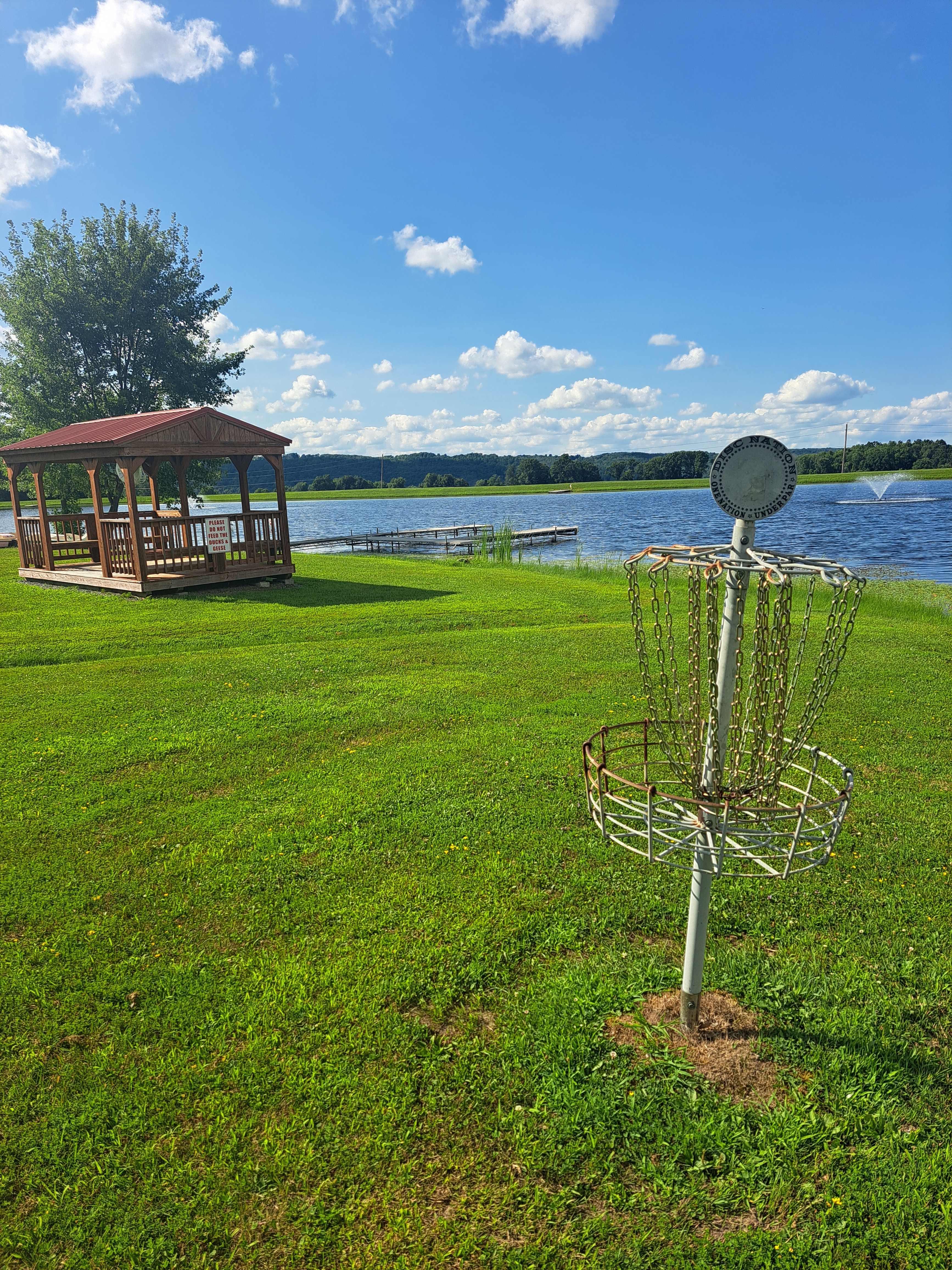 One of the disc golf baskets and the boat/fishing dock in the distance