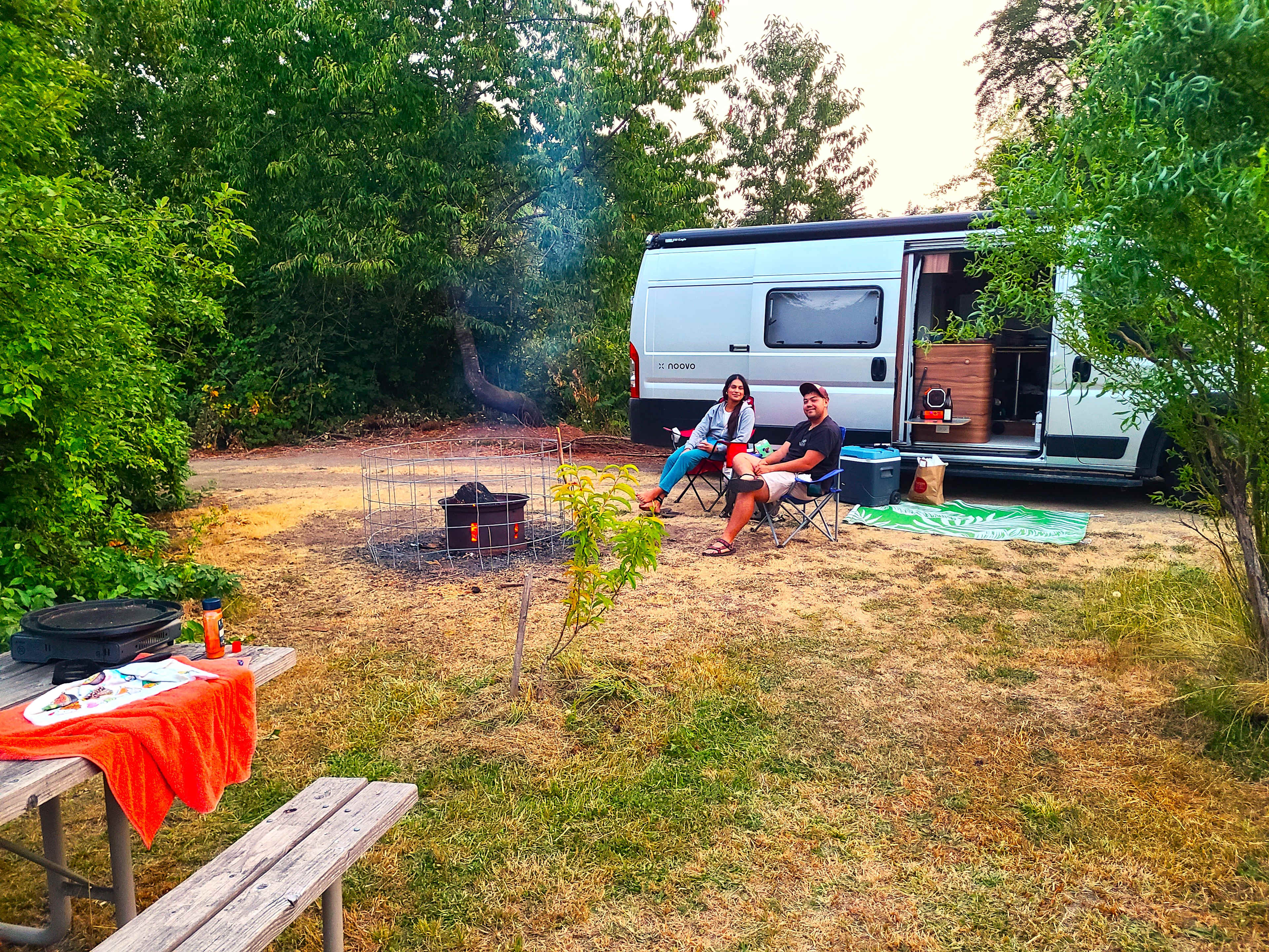 Parking on the main path near fire pit (with removable kid safety outer ring).  Old growth crab apple tree and baby nectarine tree near picnic table.