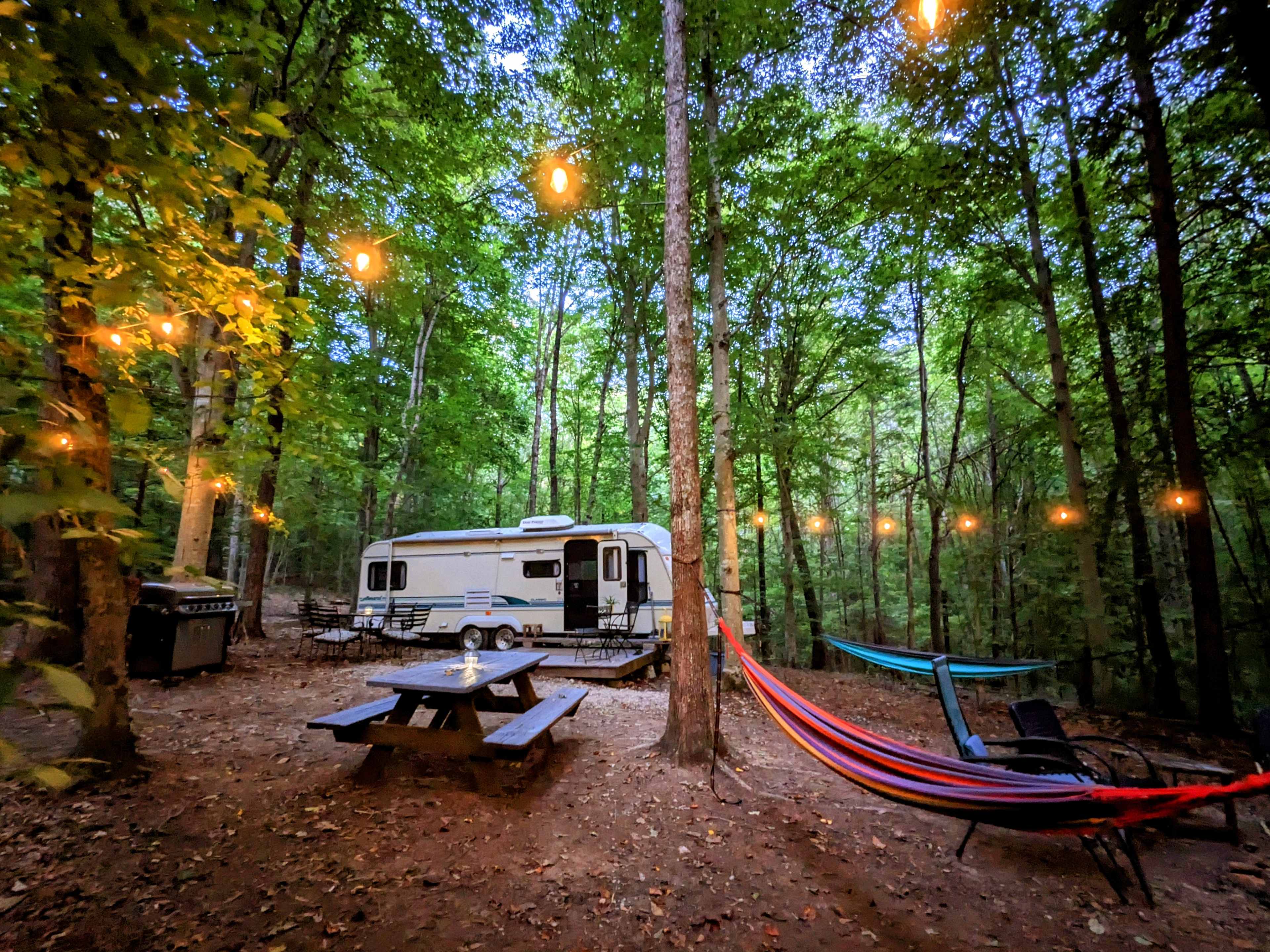 Camp in comfort in an enchanted forest! Enjoy the RV, 6-burner propane grill, lighting, and all that you see in the following photos!

Have a big group? There's plenty of room around the camper for tents. We also rent out tents, sleeping pads, etc.