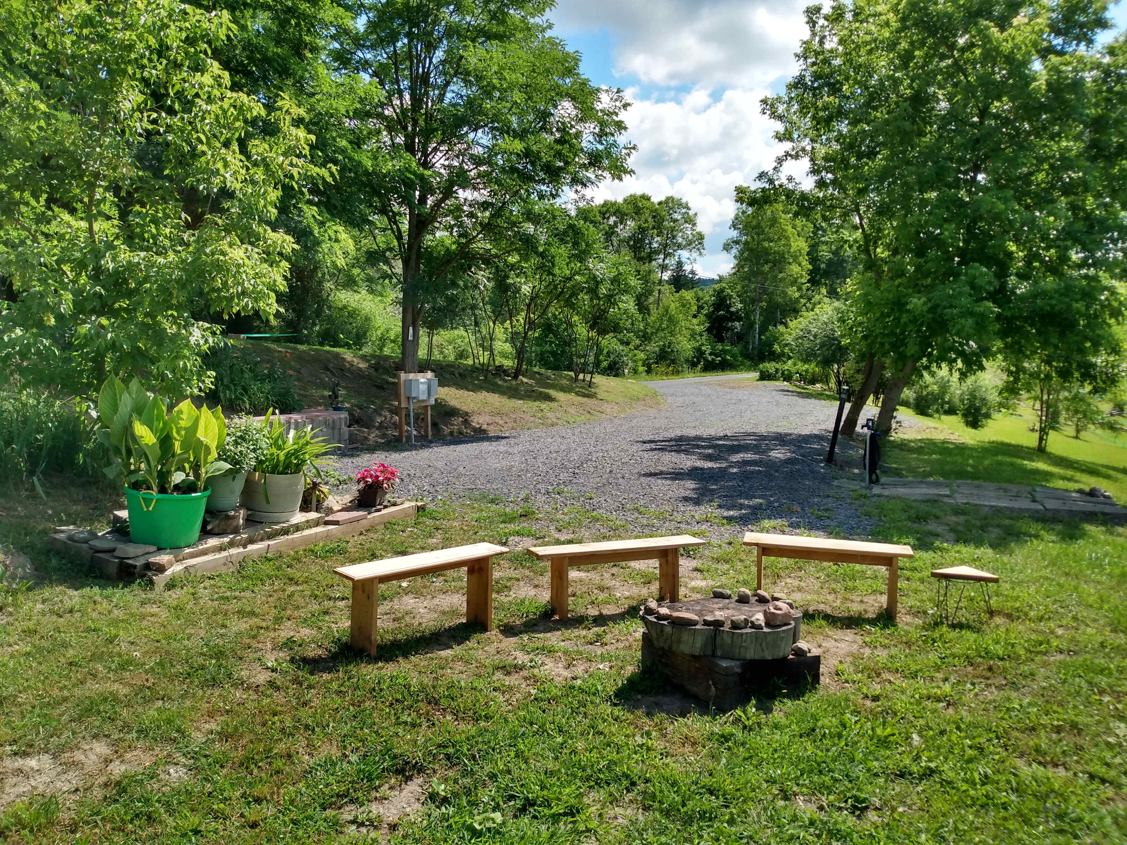 Landing-Looking from Communal Fire Pit out to entrance on country road.  Stairs (hidden in this photo to the left) up to Barn and Communal Toilet Tent and Solar Shower Tent.